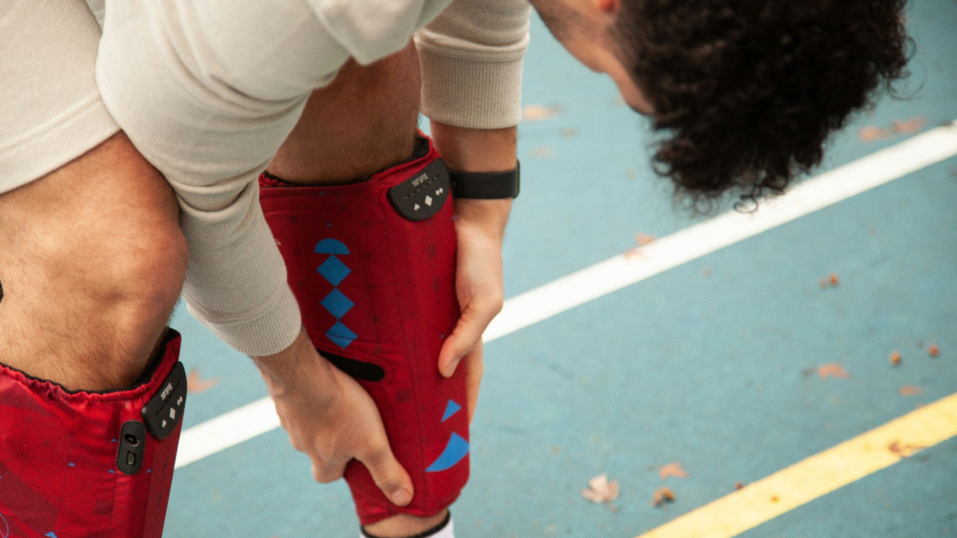 person in white shirt and red shorts wearing white nike sneakers