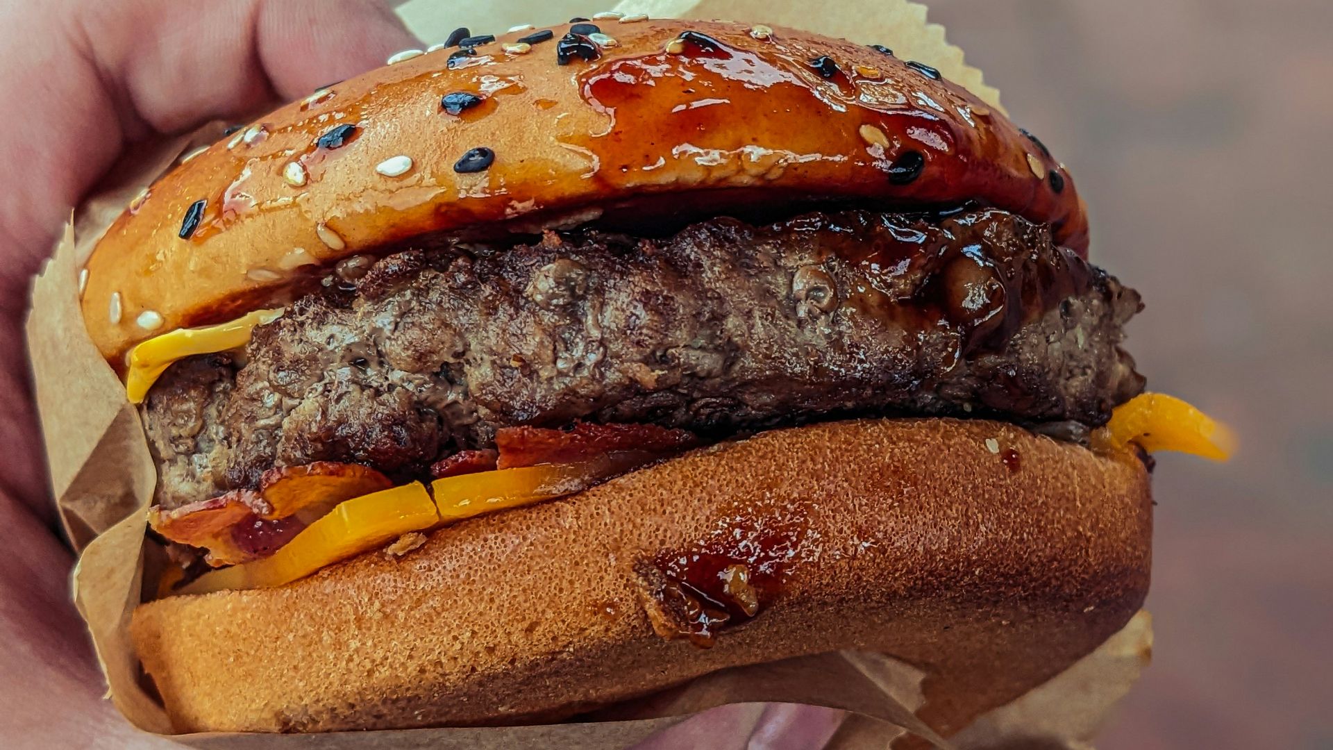 a person holding a hamburger in their hand