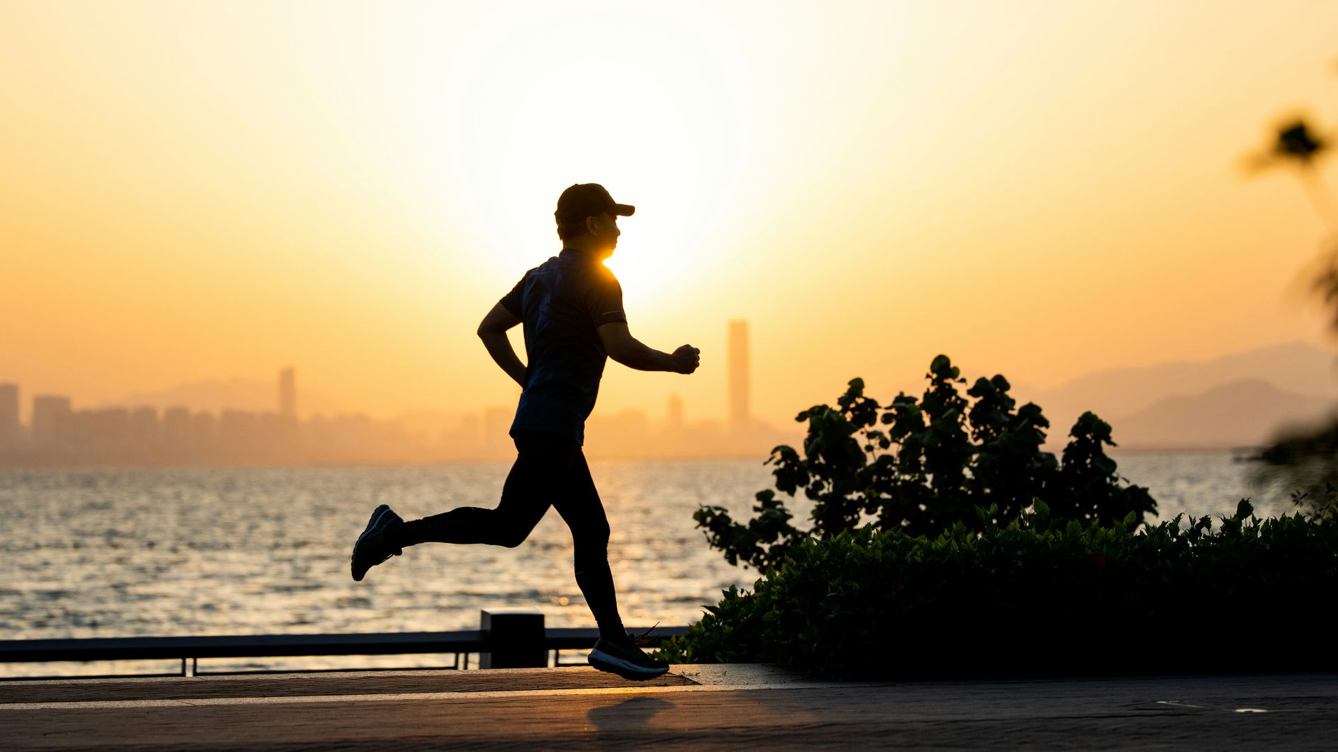a man running on the beach at sunset