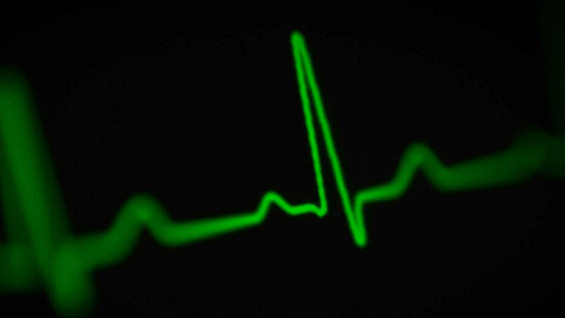 a green heart beat on a black background