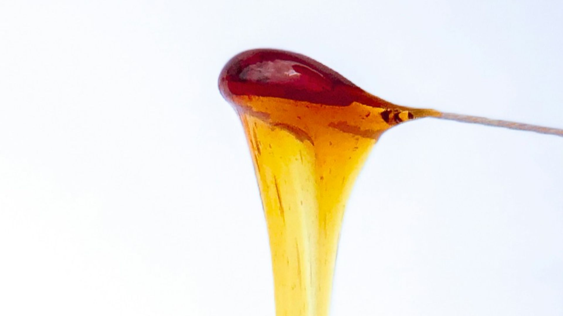 a jar of sugar wax with a spoon sticking out of it