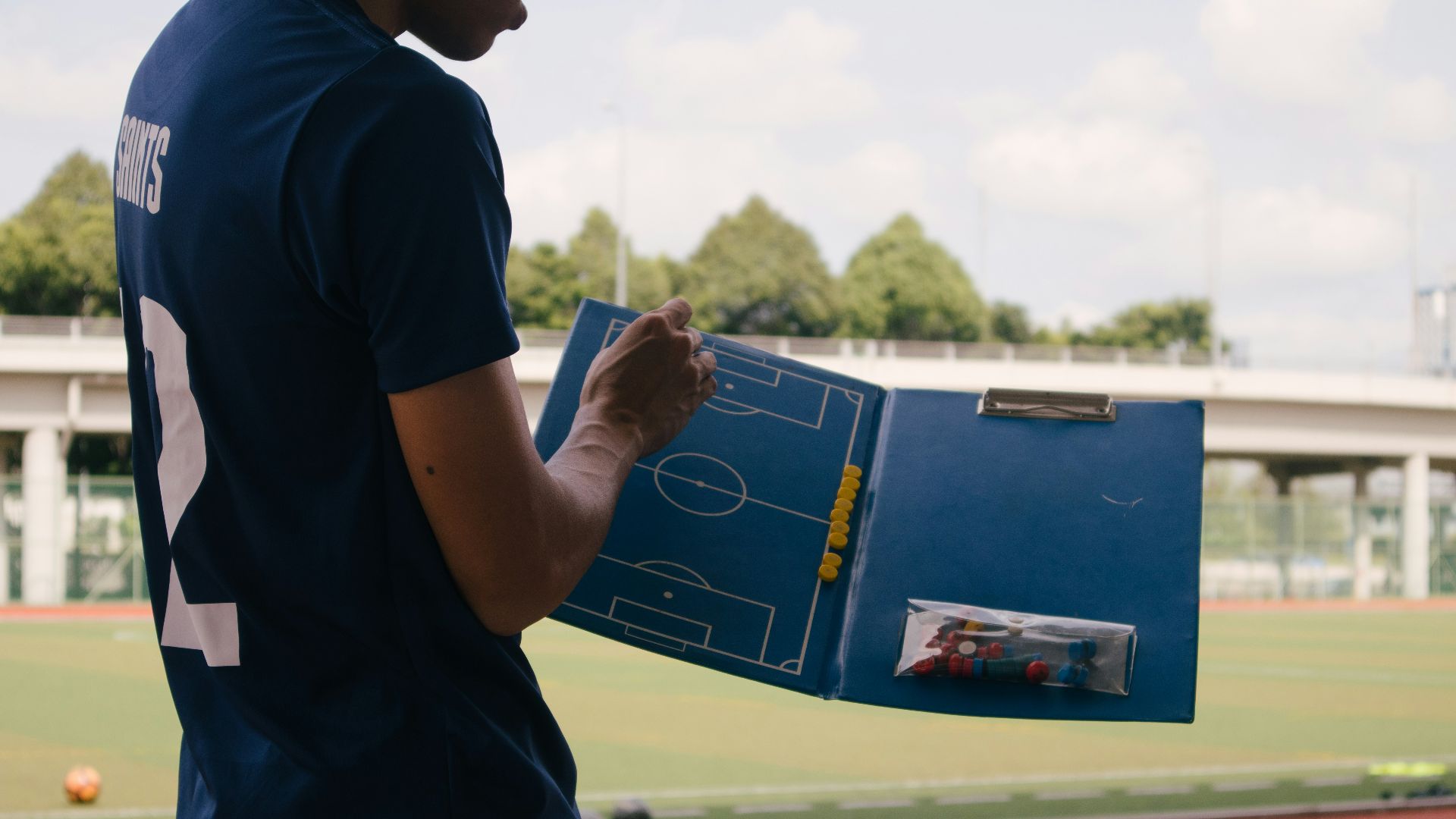 man in blue crew neck t-shirt standing on track field during daytime