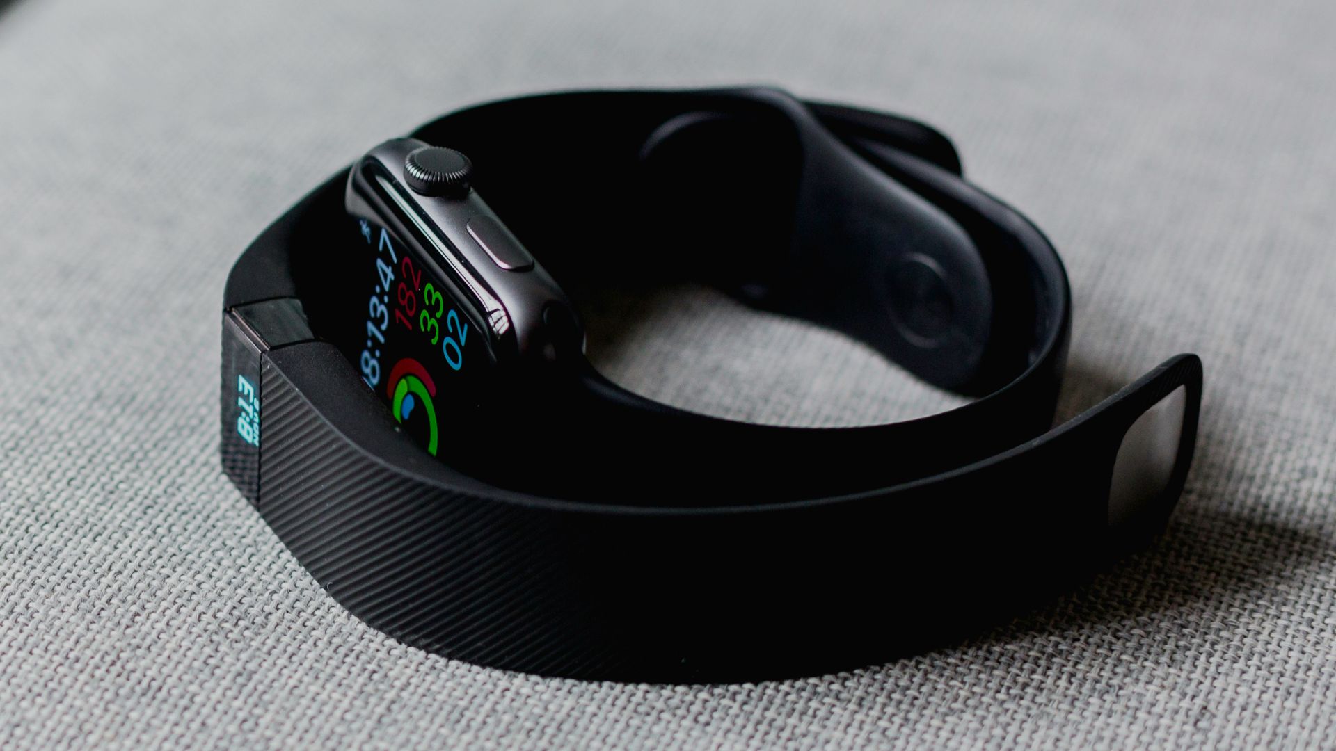 black aluminum case Apple Watch and black Fitbit charge 2