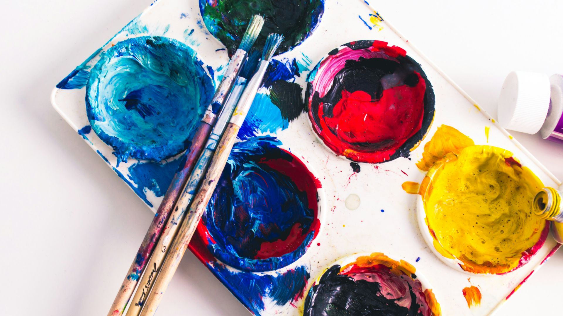 brown paint brushes on assorted-color paint palette