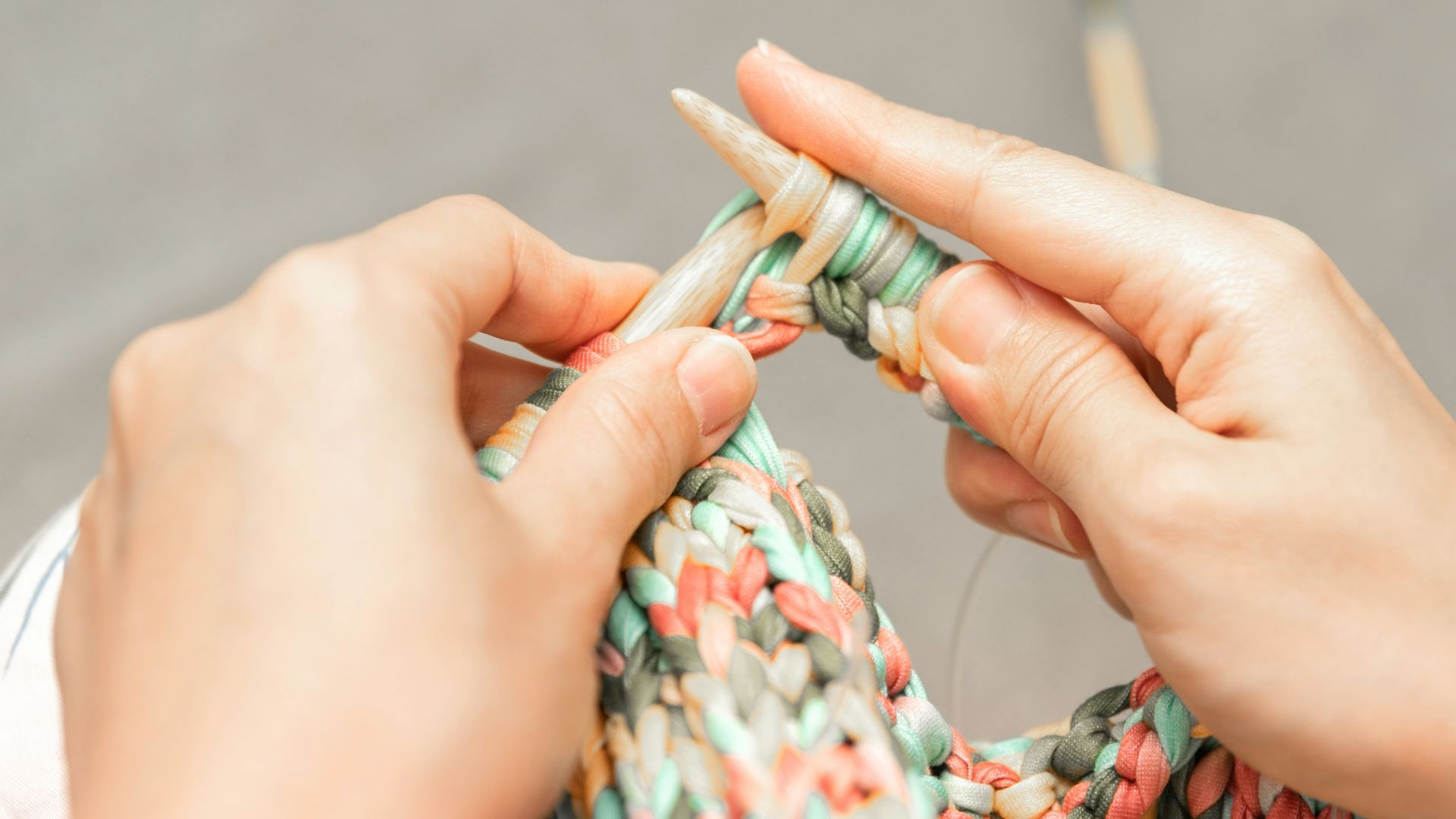 a woman is knitting a piece of fabric