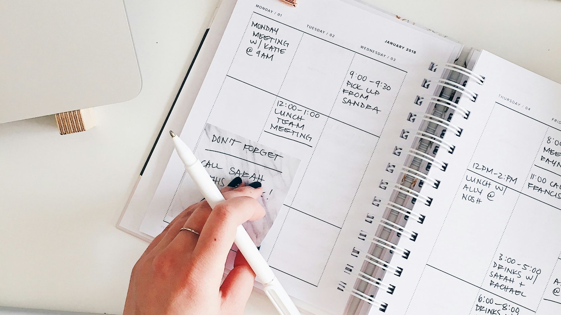 person holding notepad and pen flat lay photography