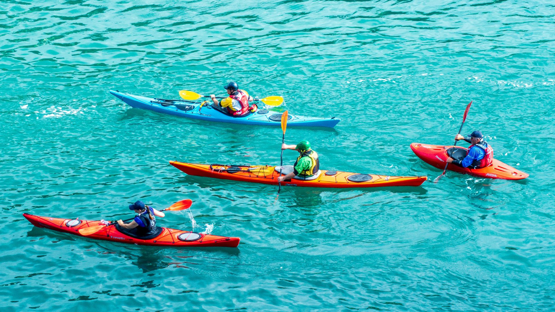 2 person riding on red kayak on body of water during daytime