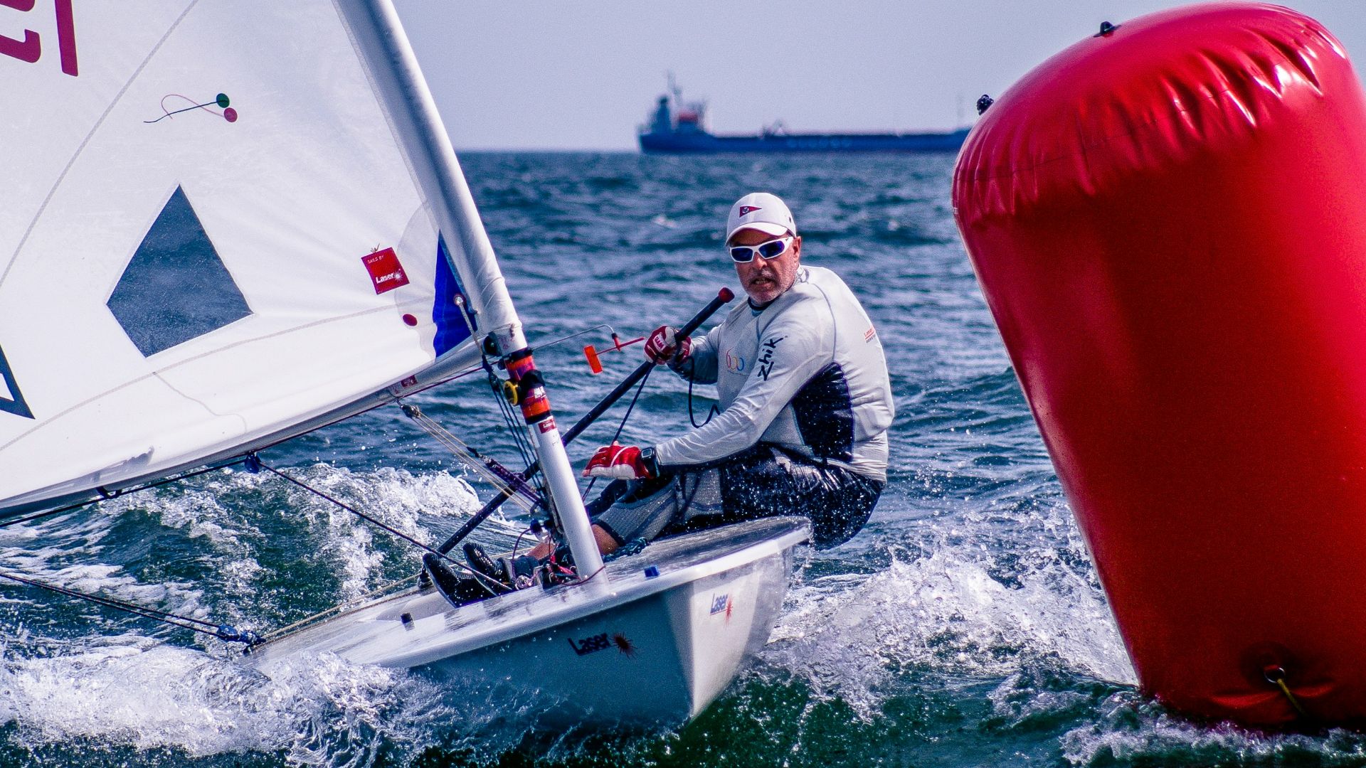 man riding on sailboat near red float during daytime