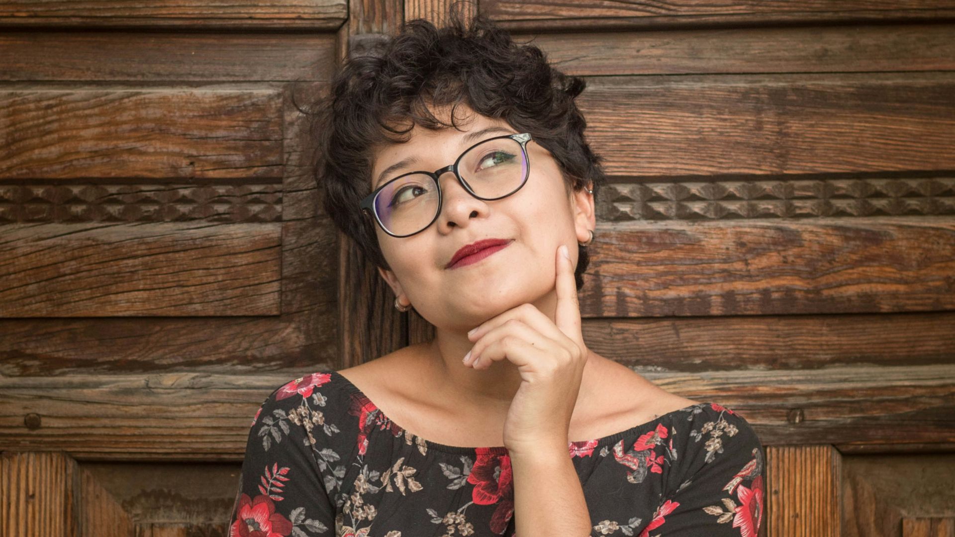 woman leaning against door while holding her cheek