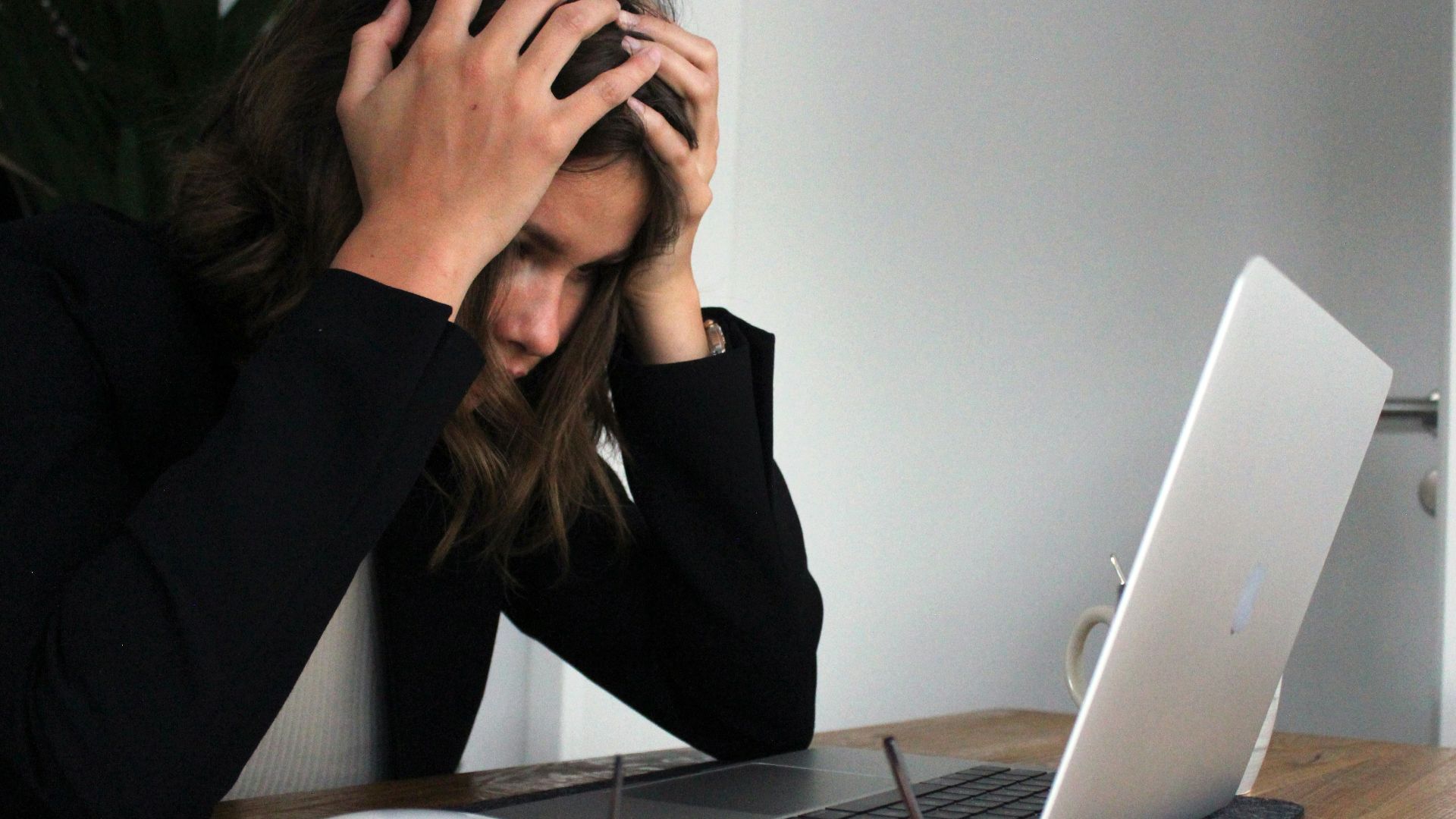 a woman sitting in front of a laptop computer