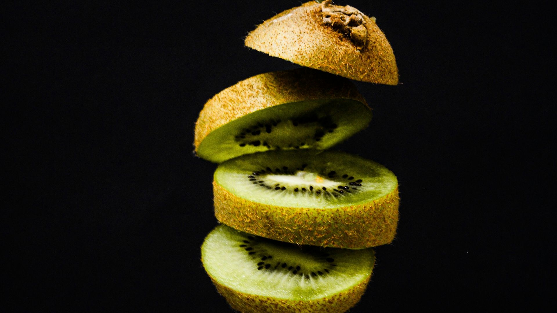 sliced green fruit on black background
