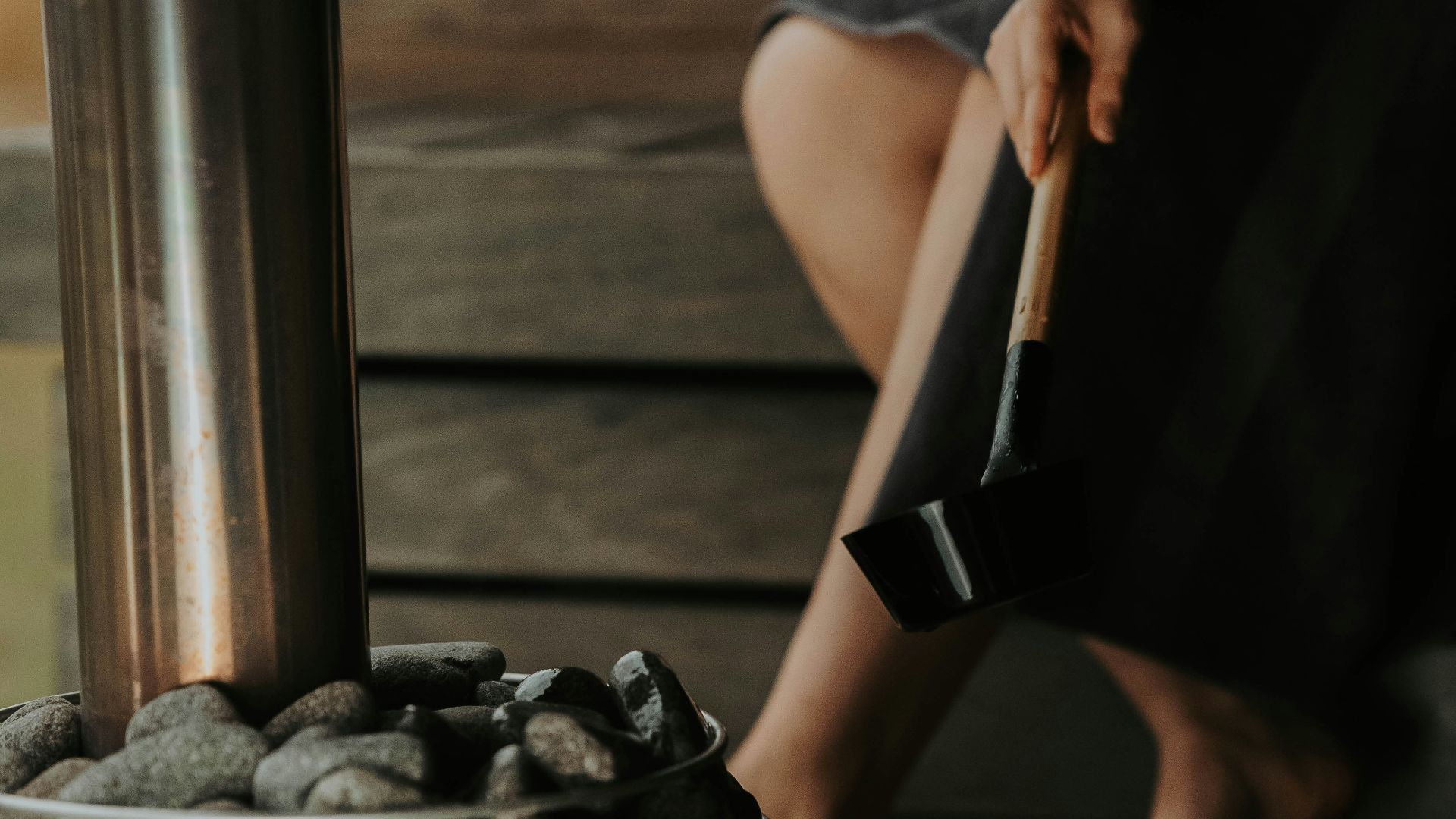 a woman sitting on a bench next to a pile of rocks