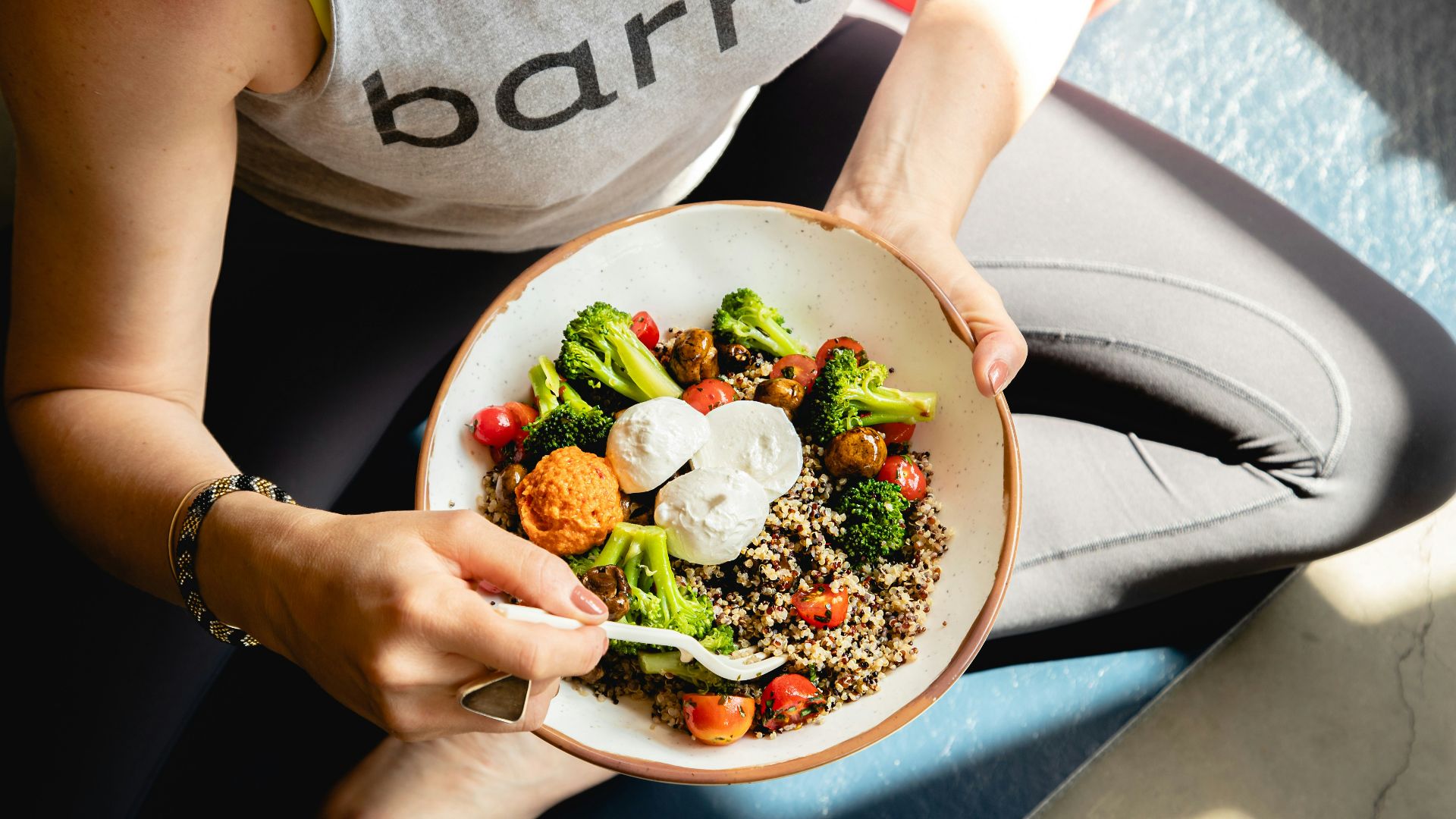 a woman is holding a bowl of food