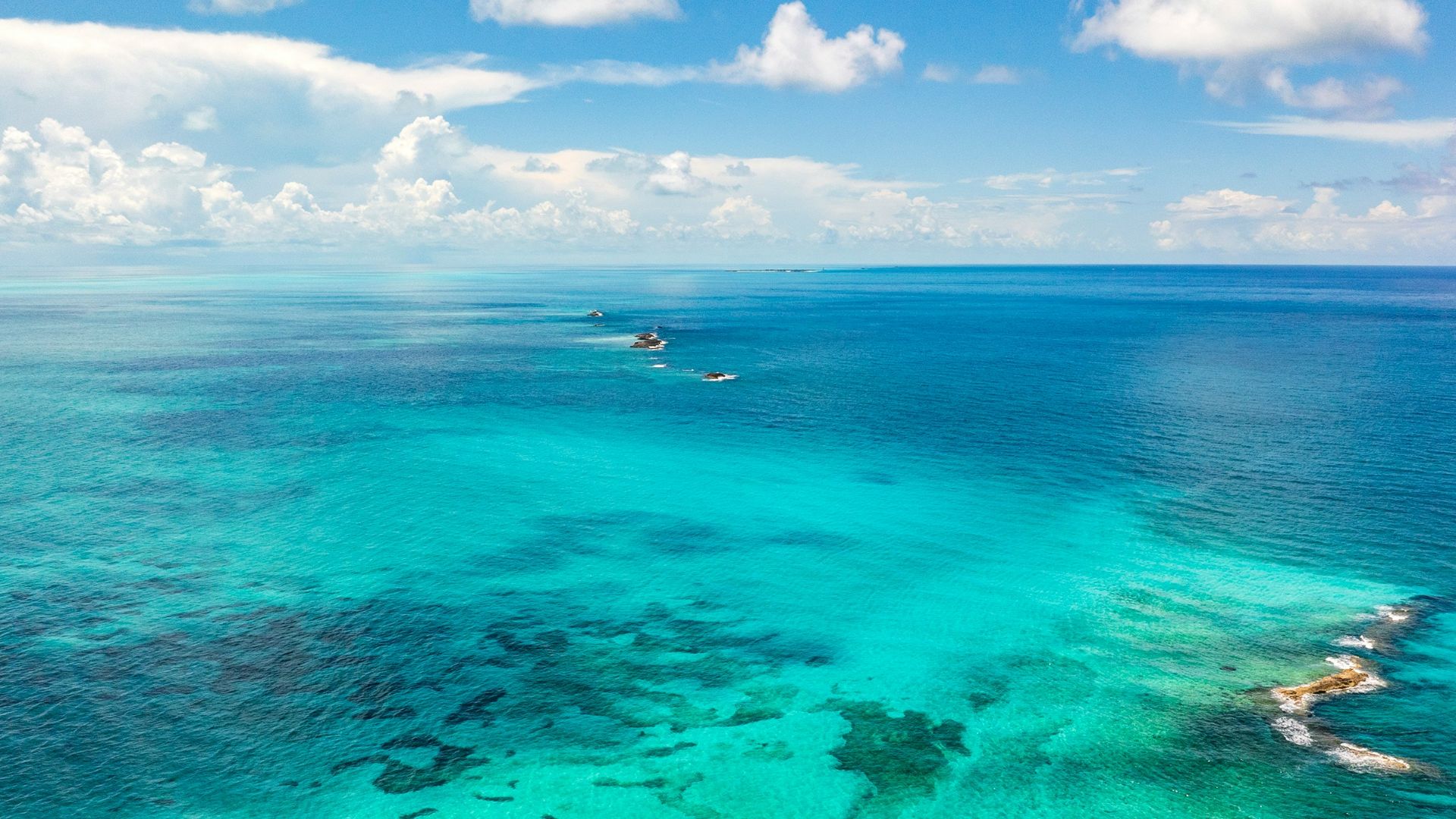 An aerial view of the ocean with boats in the water