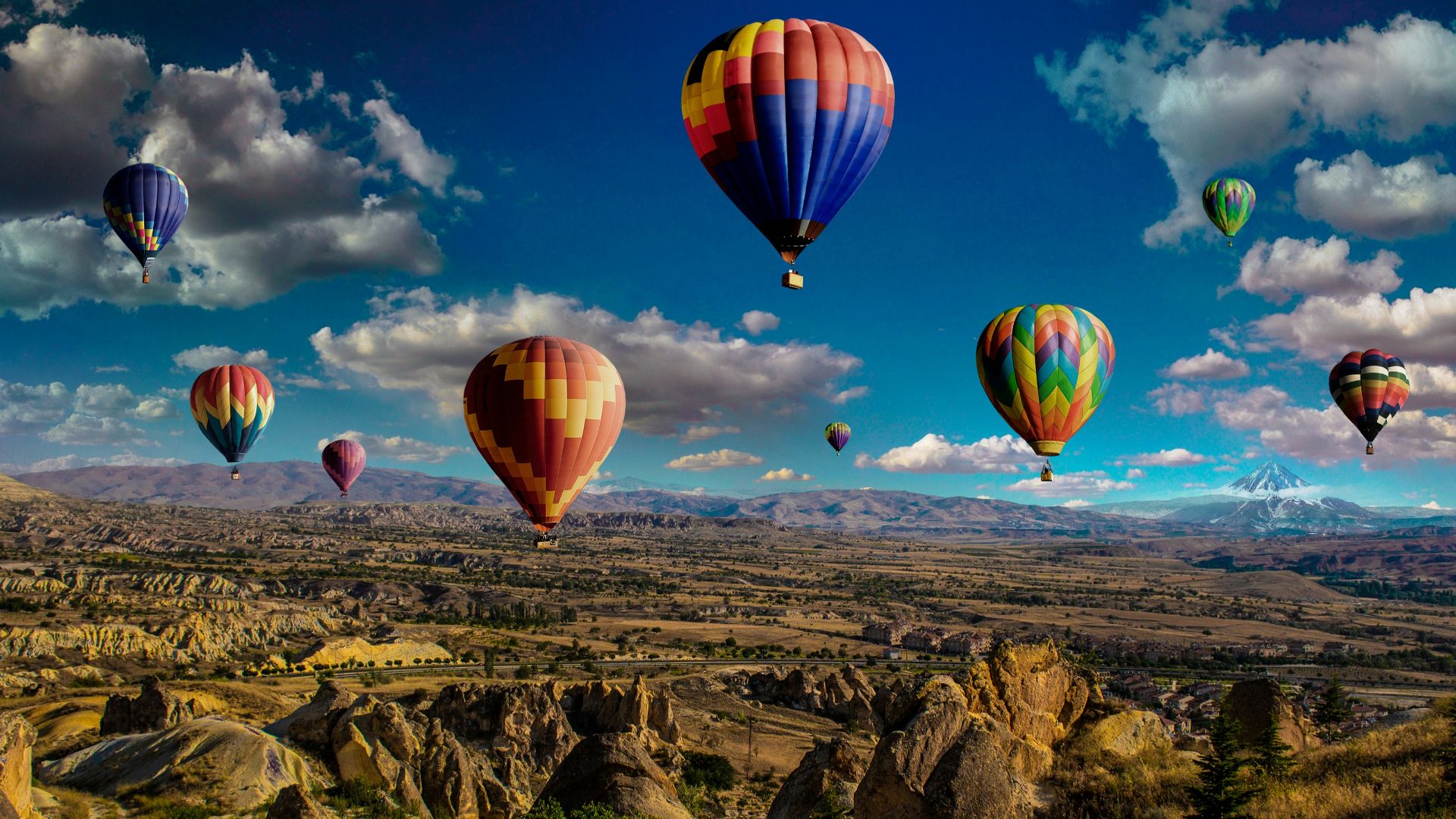 assorted-color hot air balloons over brown mountain range during daytime