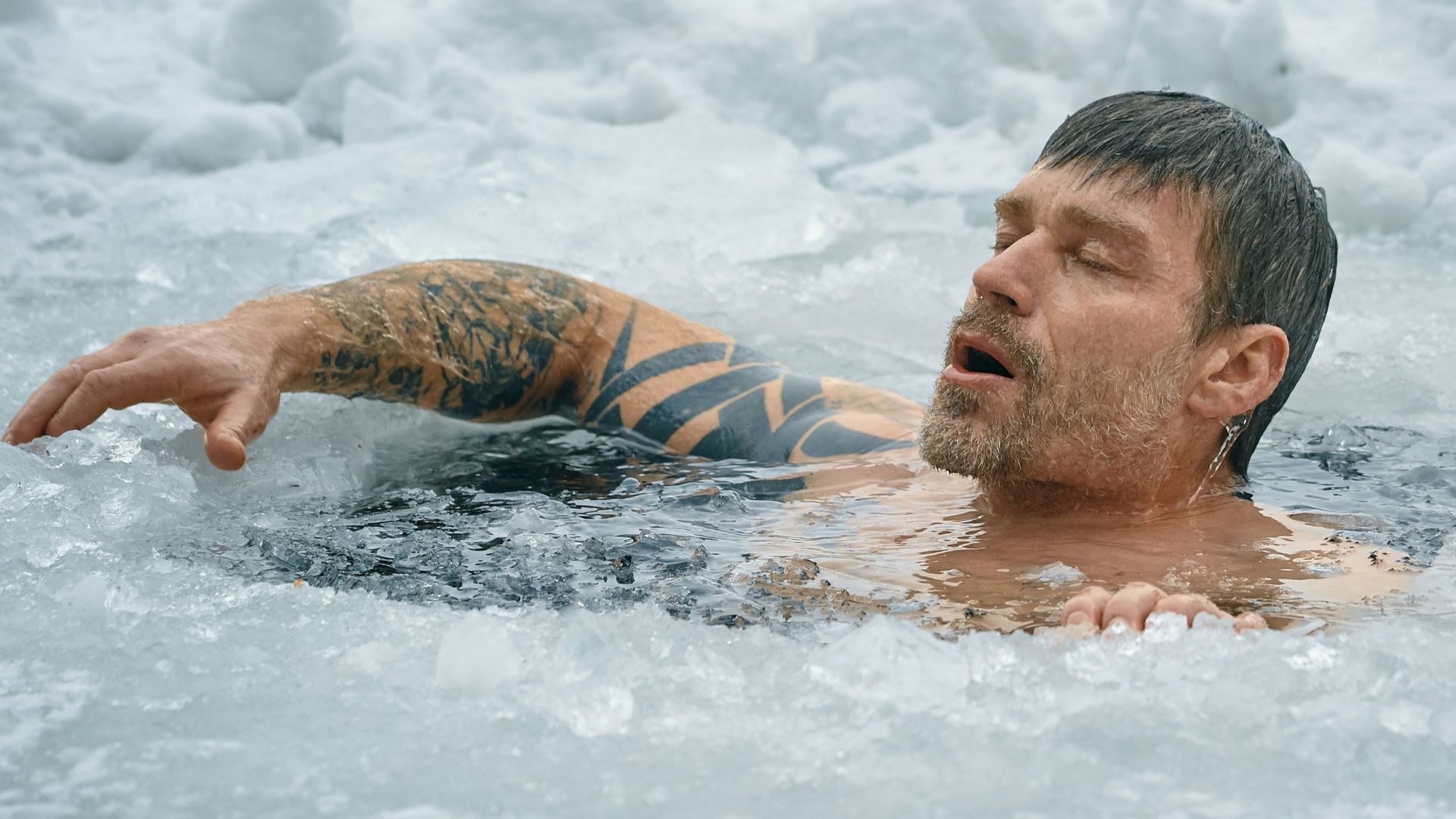 man swimming on frozen water