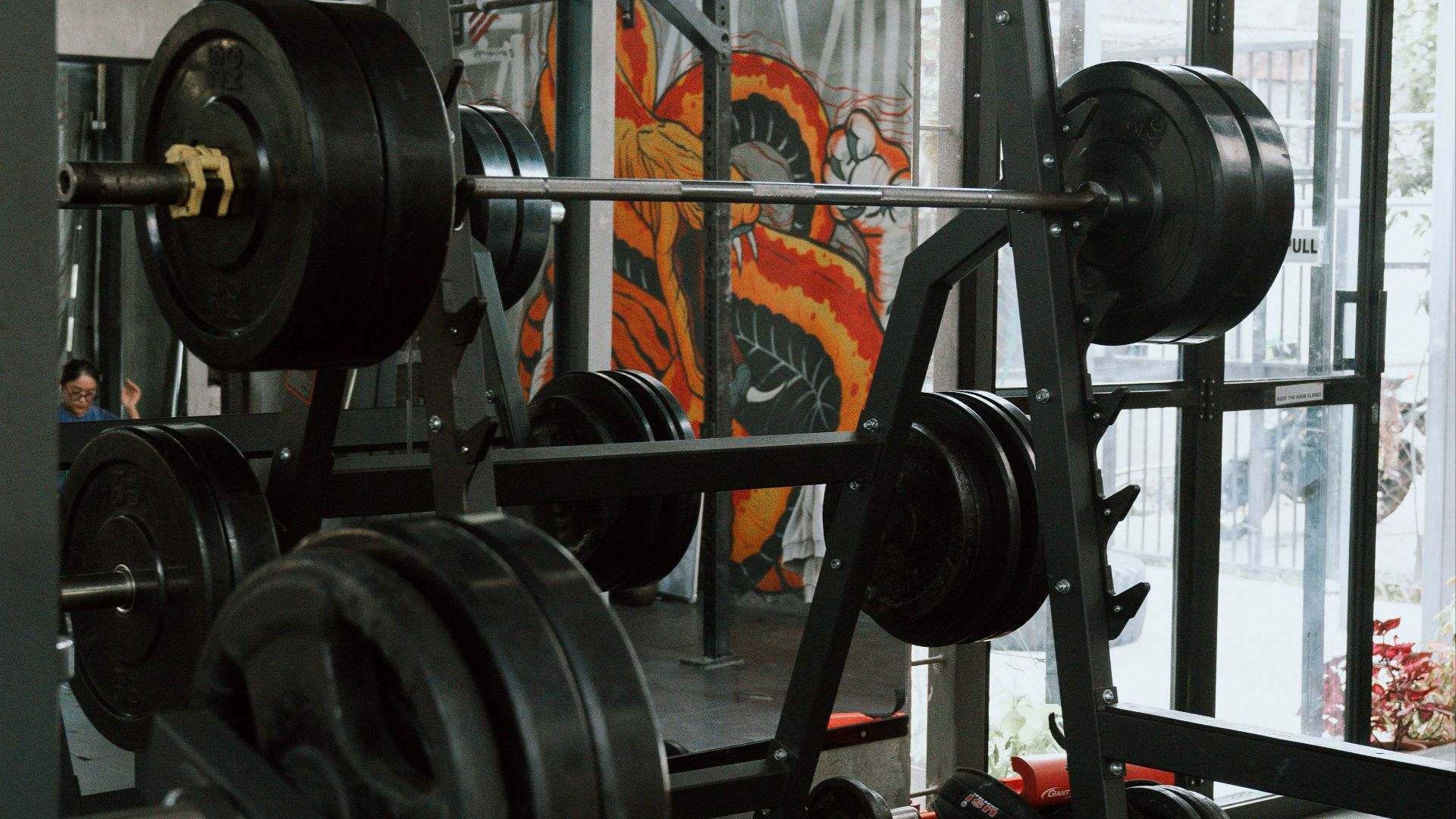 A man in a gym holding a barbell