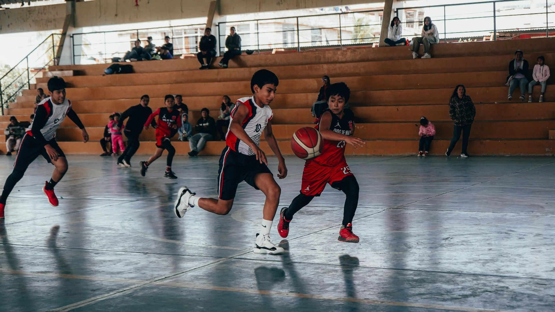 A group of young men playing a game of basketball
