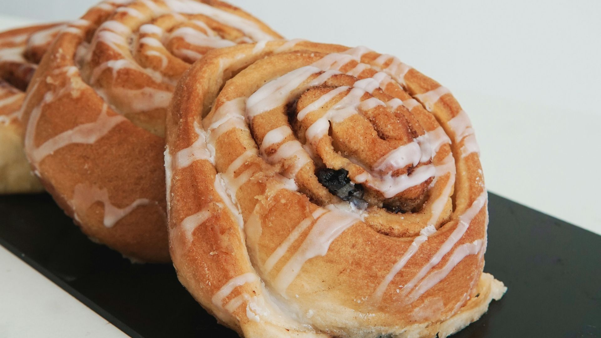 a couple of cinnamon rolls sitting on top of a black plate