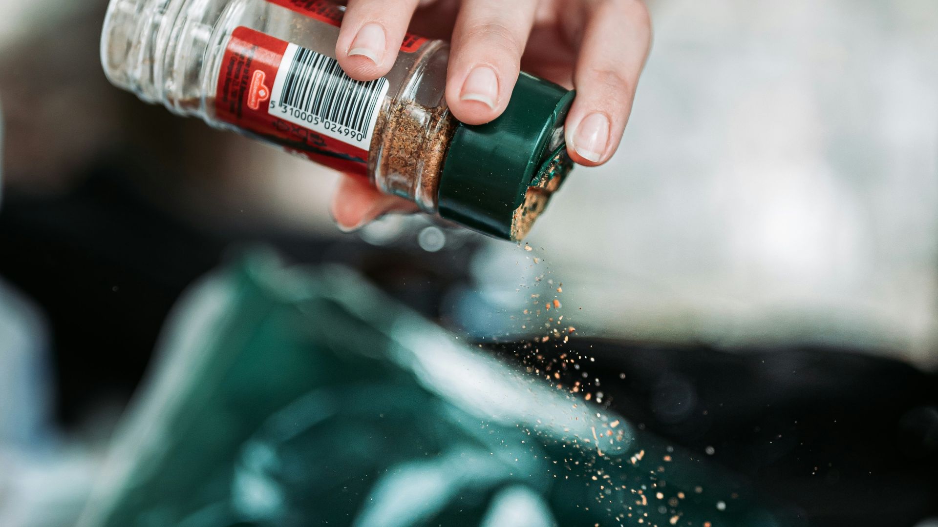 person holding green and red bottle