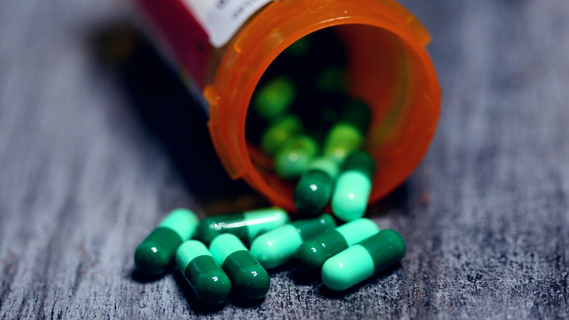 shallow focus photography of prescription bottle with capsules