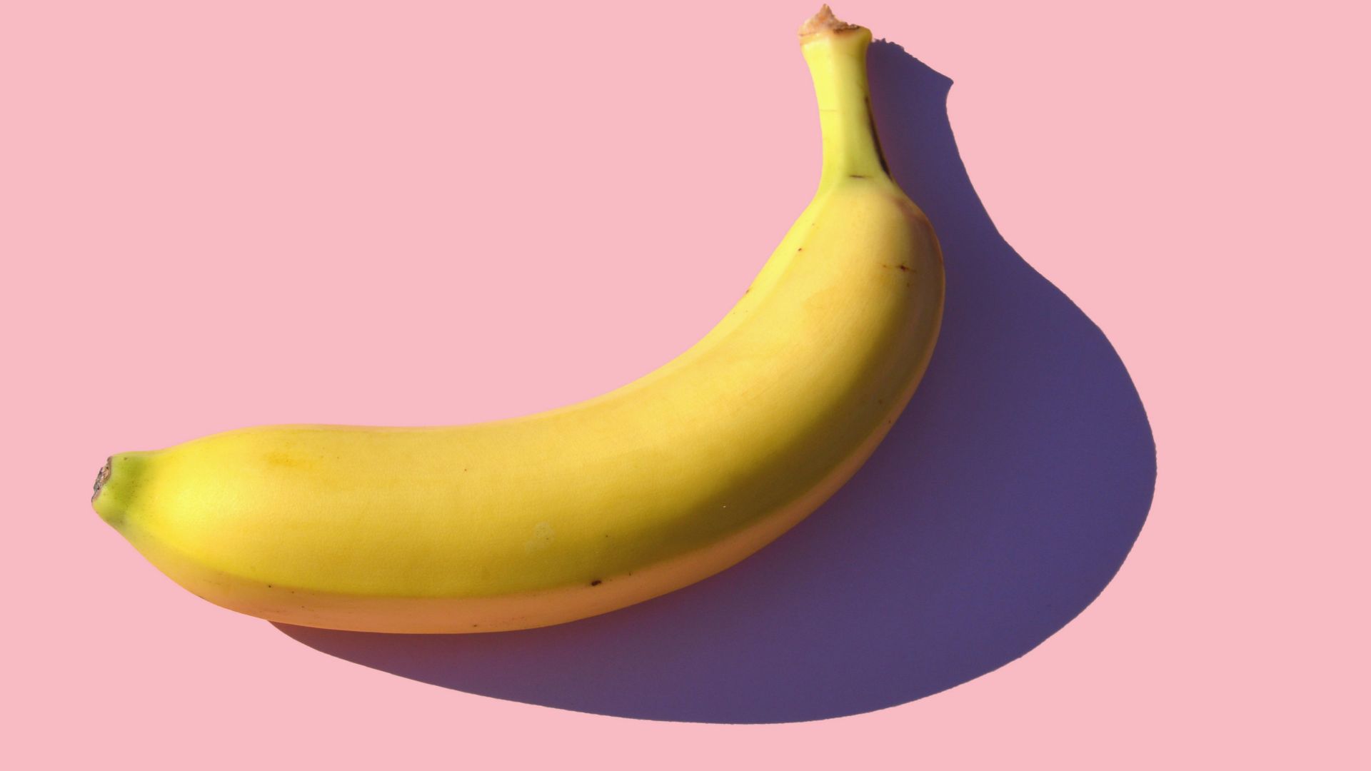 riped banana on pink surface