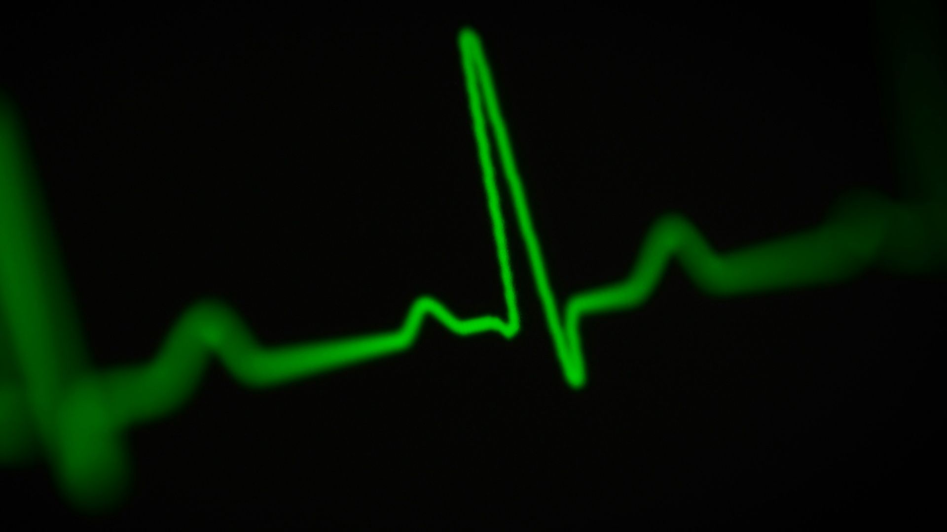 a green heart beat on a black background