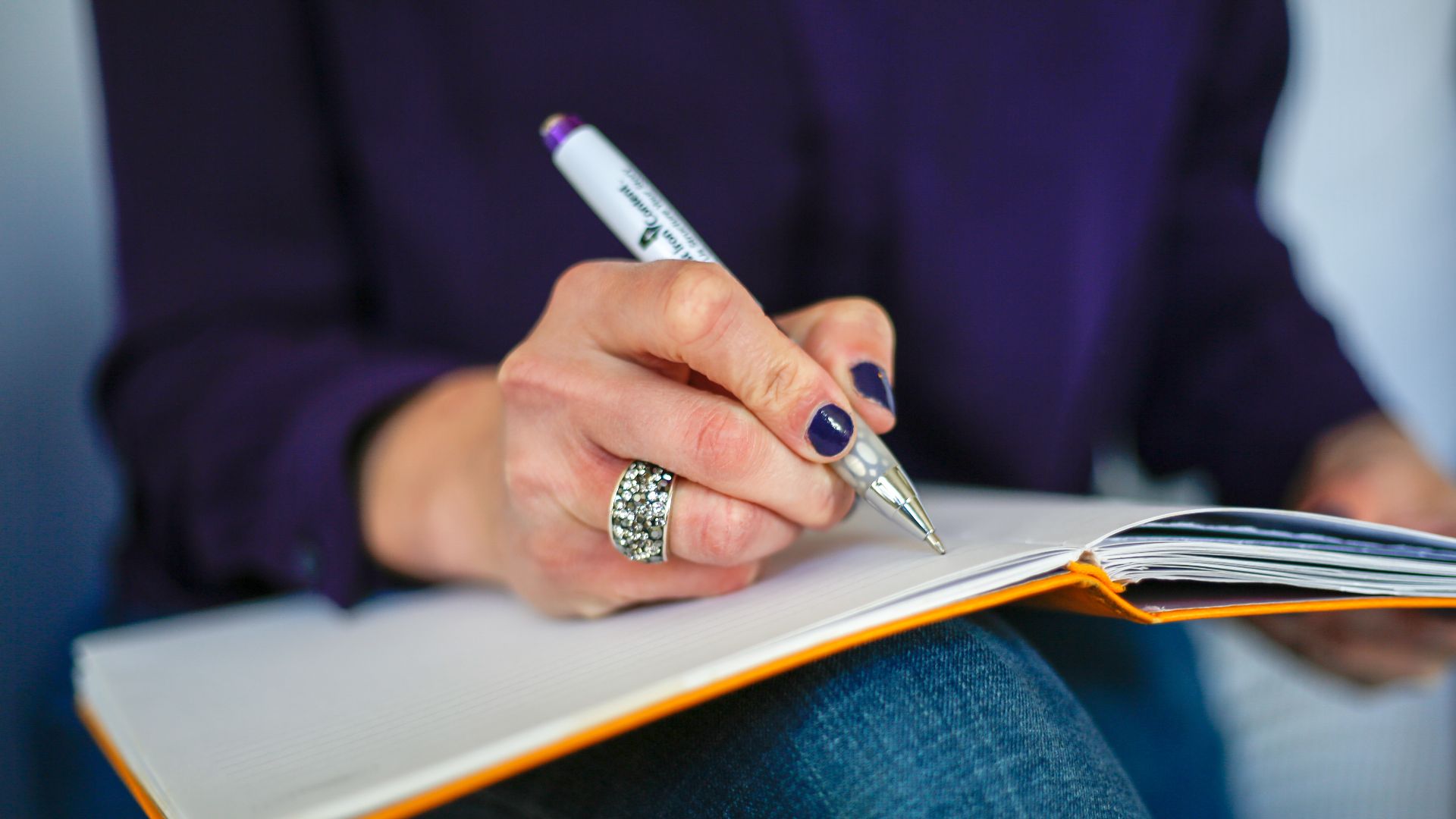 File:Woman writing on a notebook with a pen.jpg