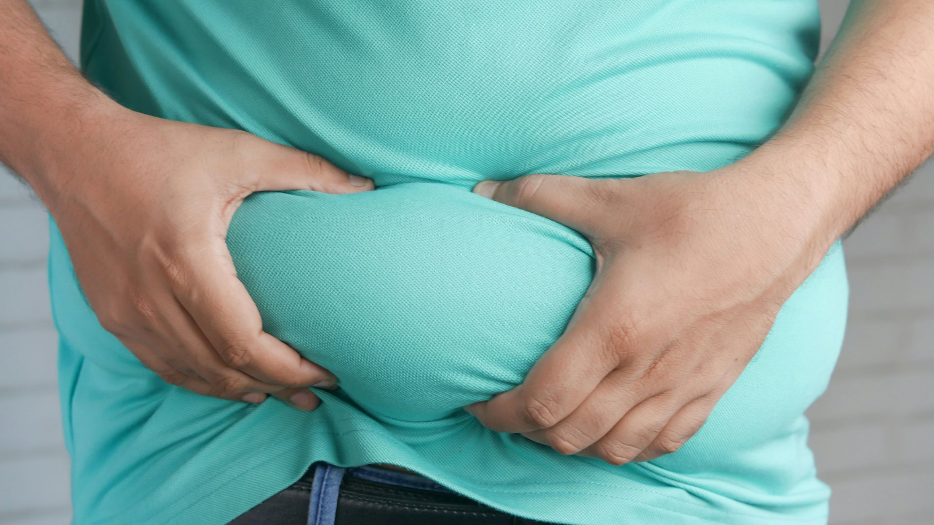 a man holding his stomach with his hands