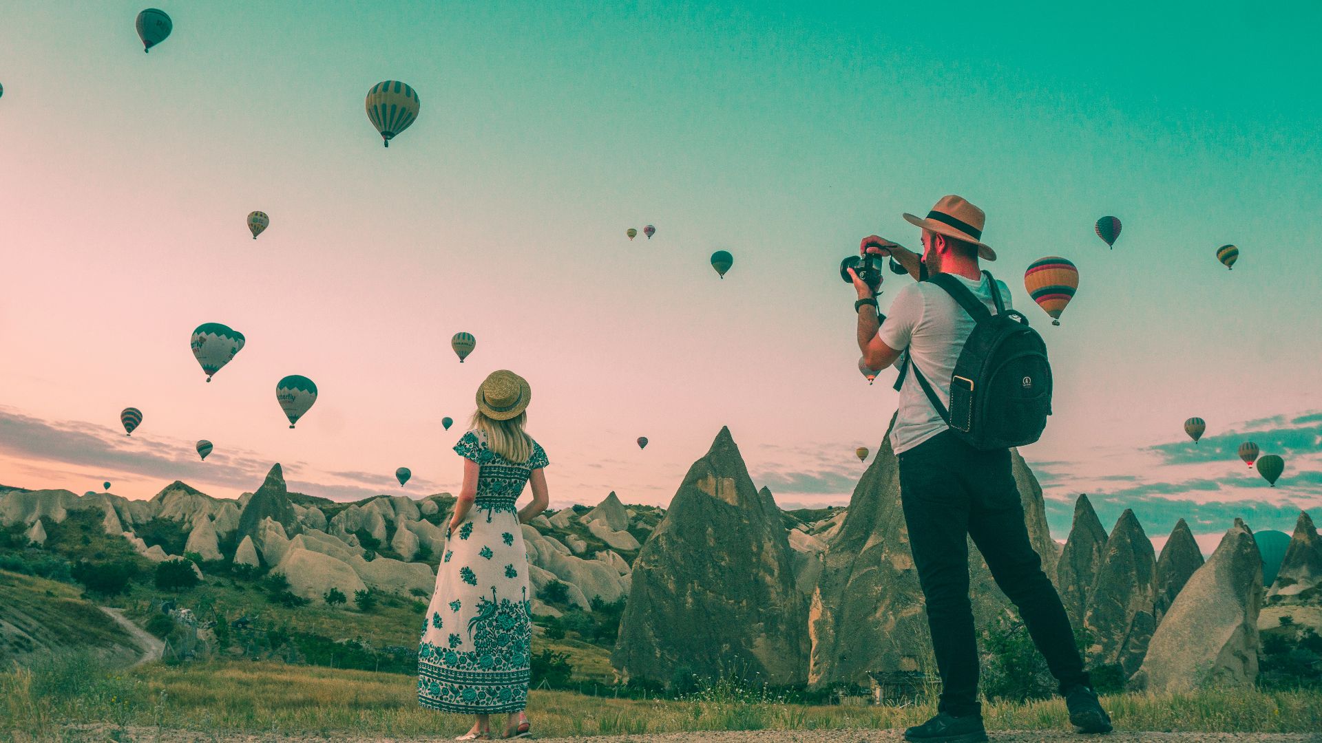 man taking photo of hot air balloons