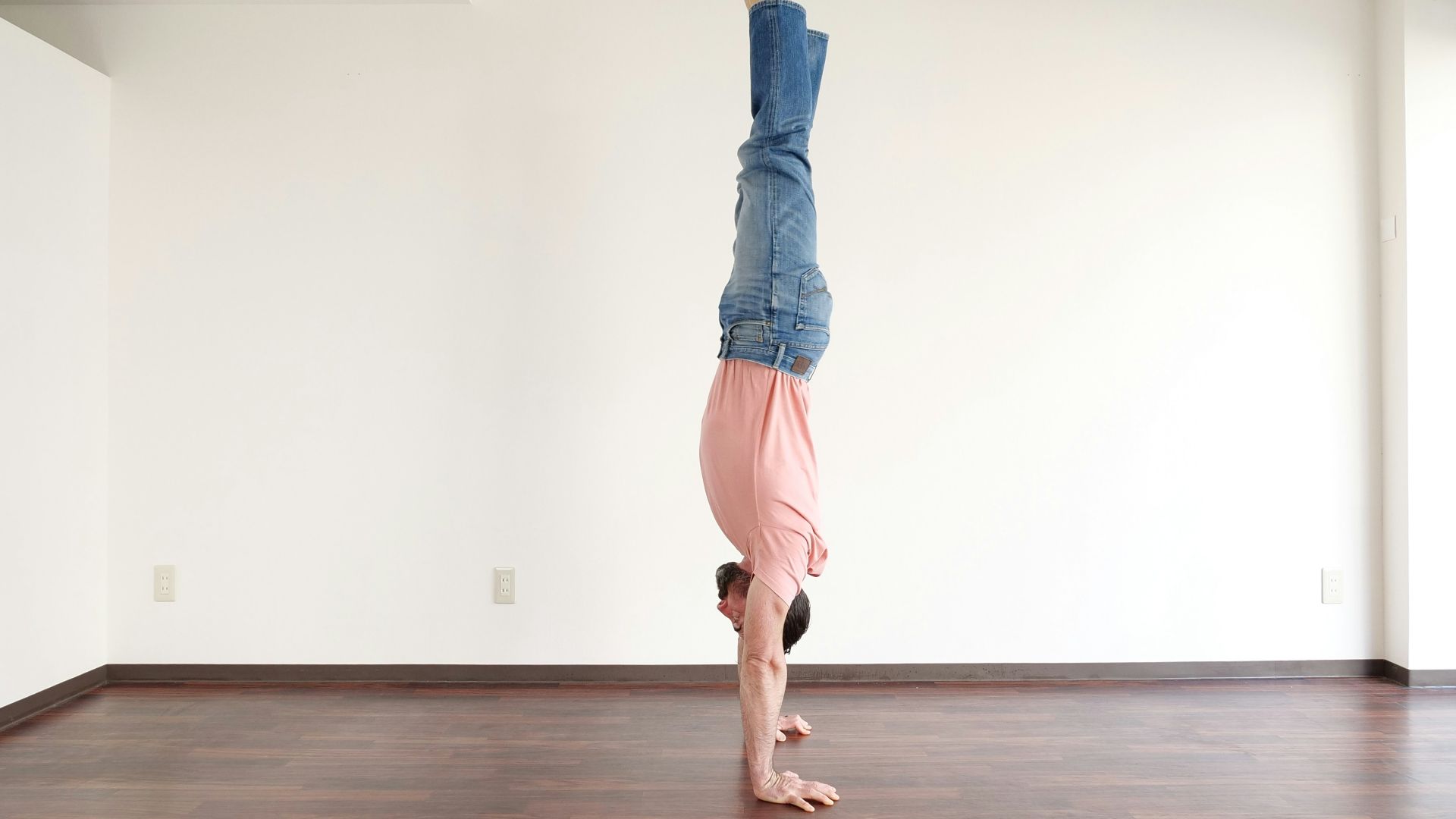 a person doing a handstand on a wooden floor