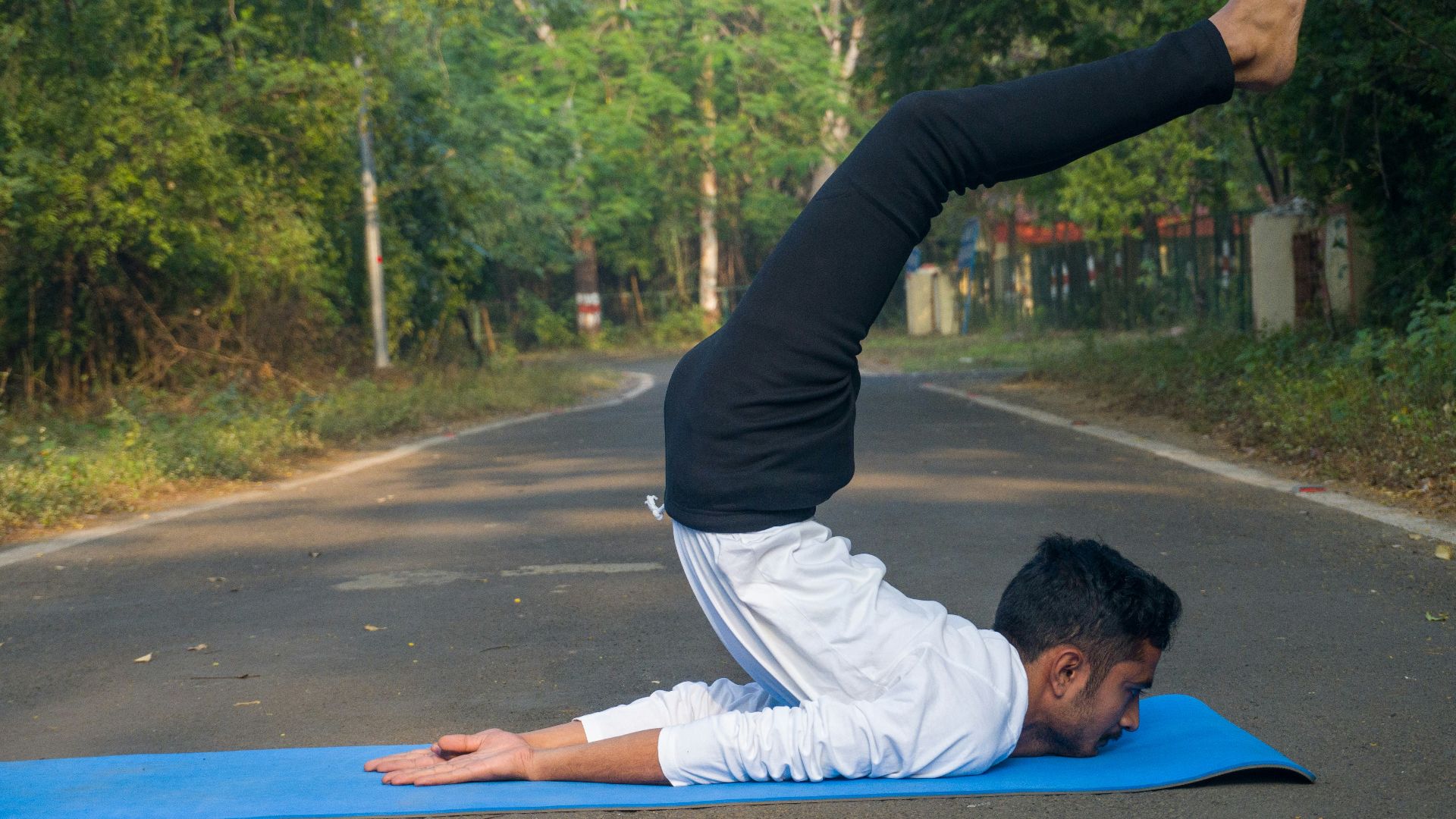 A man doing a yoga pose on a blue mat