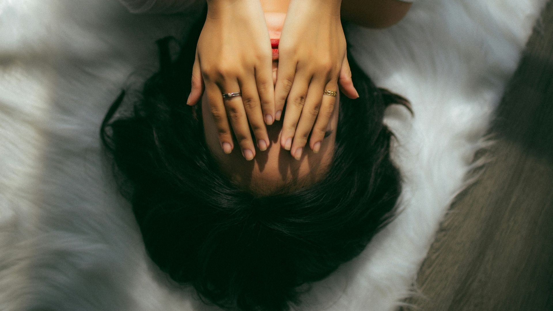 a woman holds her hands over her face