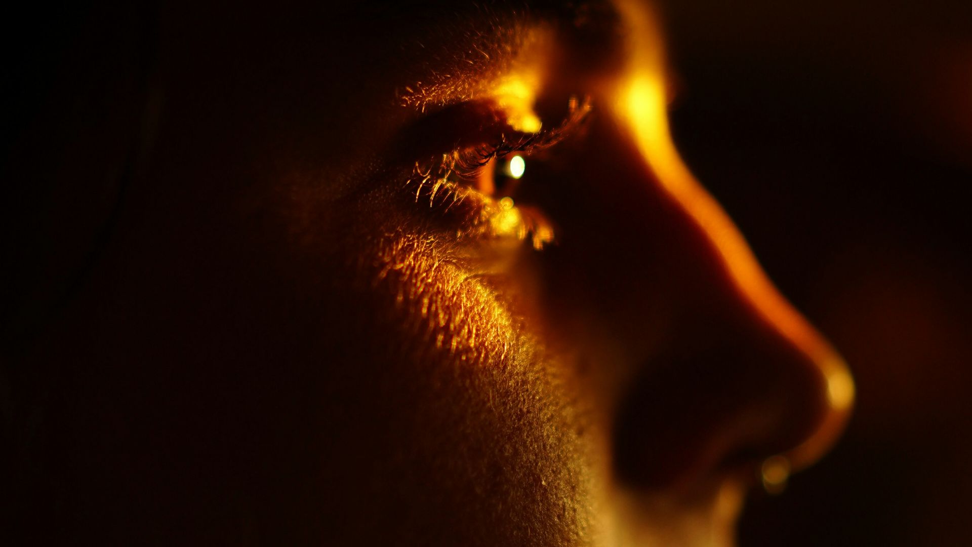 a woman in the dark with her hand on her face