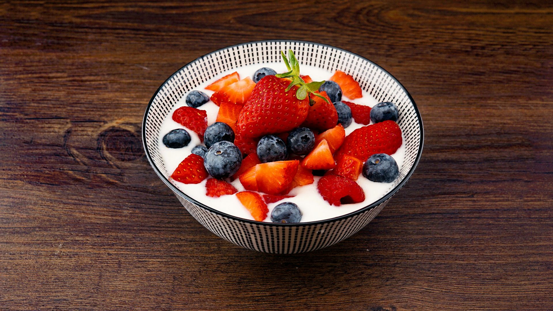 strawberry and blackberries on top of brown table