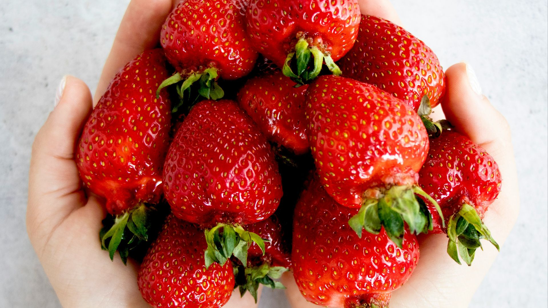 strawberries on persons hand