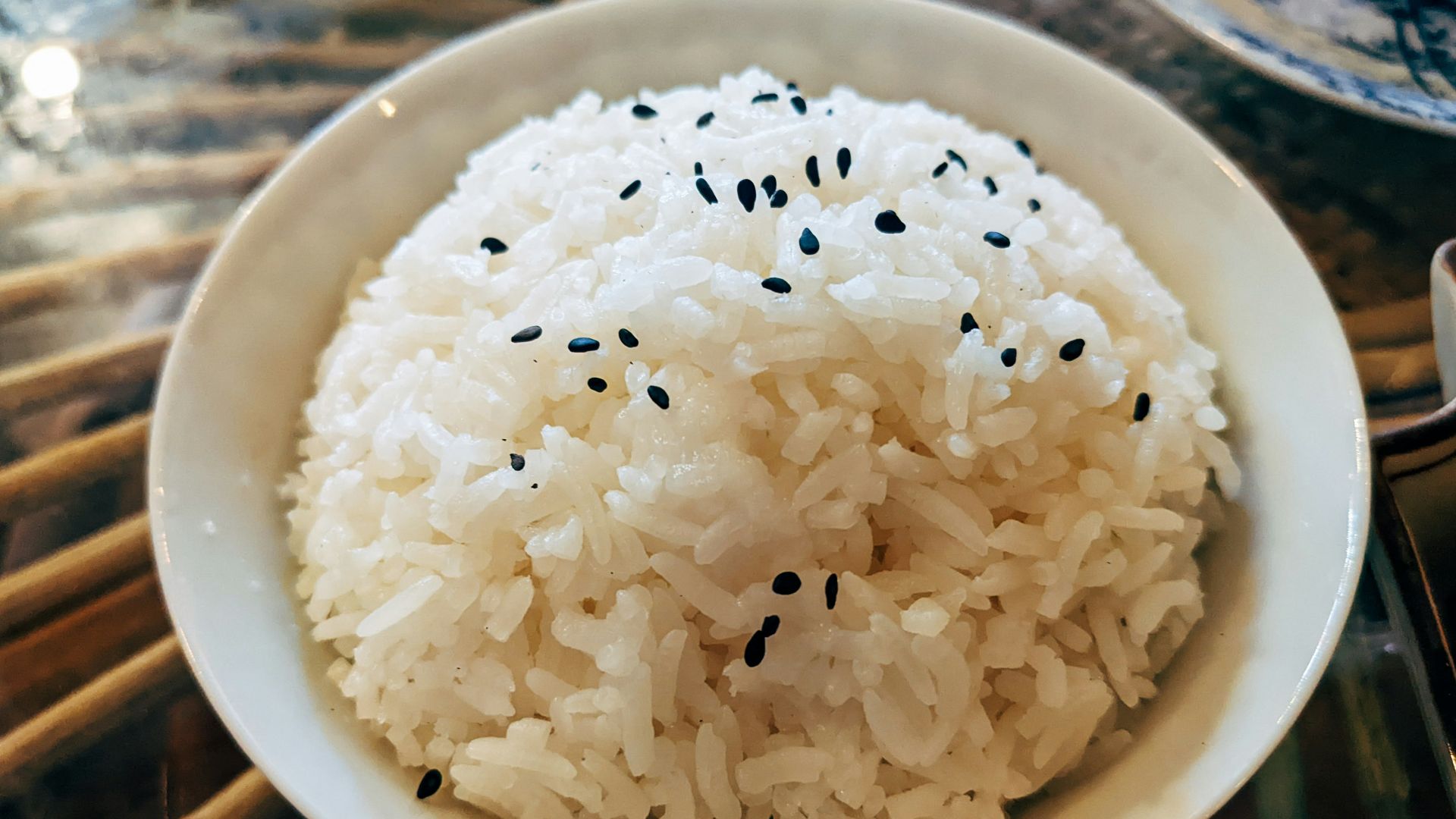 a bowl of white rice with black sesame seeds