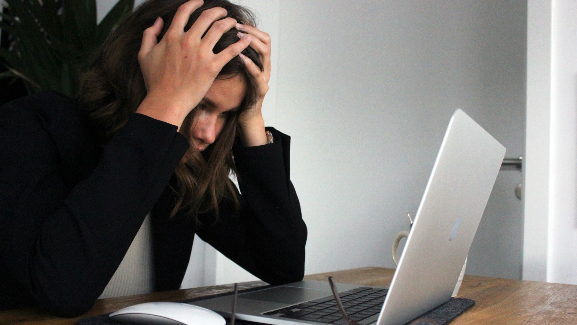 a woman sitting in front of a laptop computer