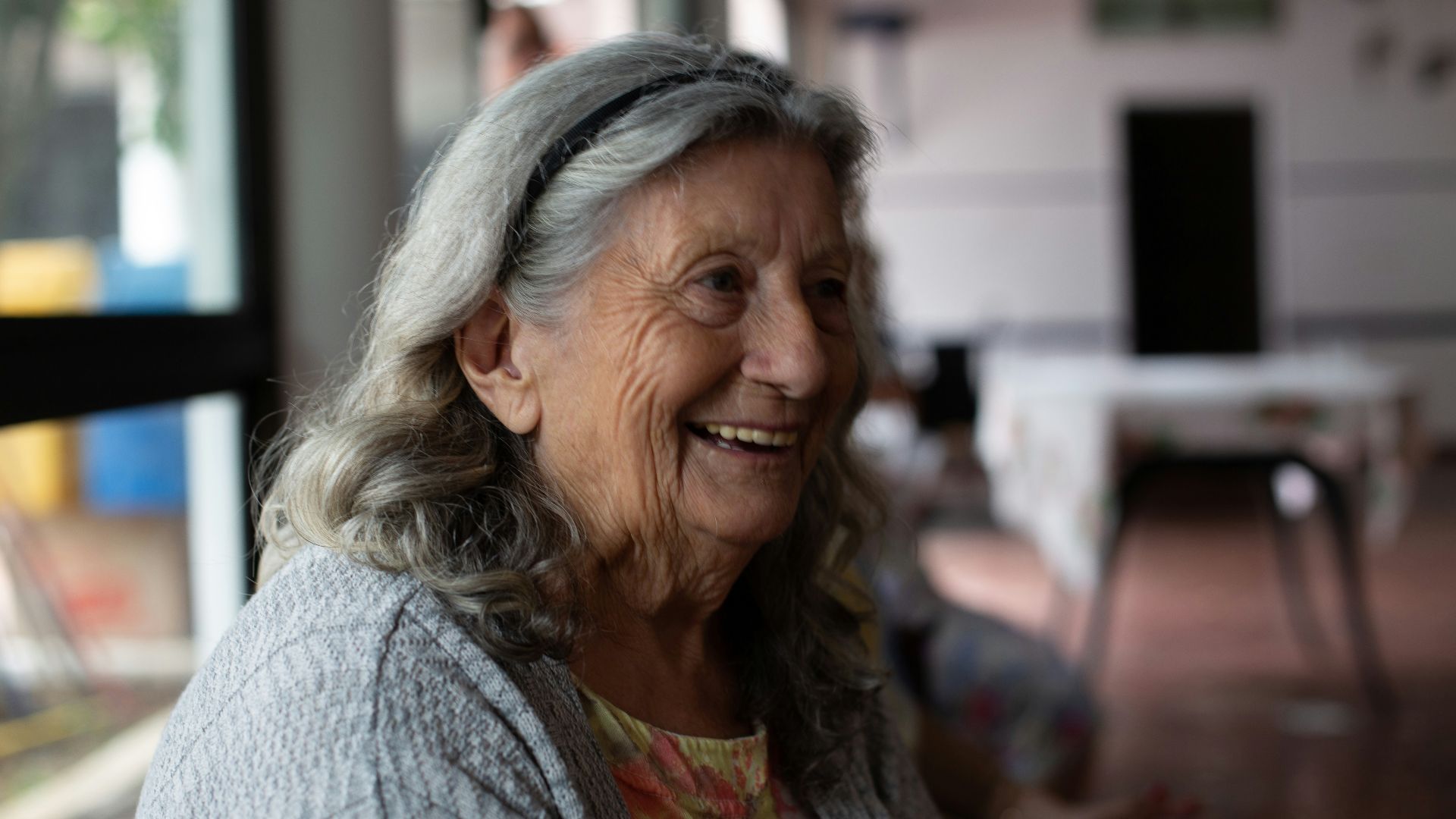 smiling woman in gray cardigan