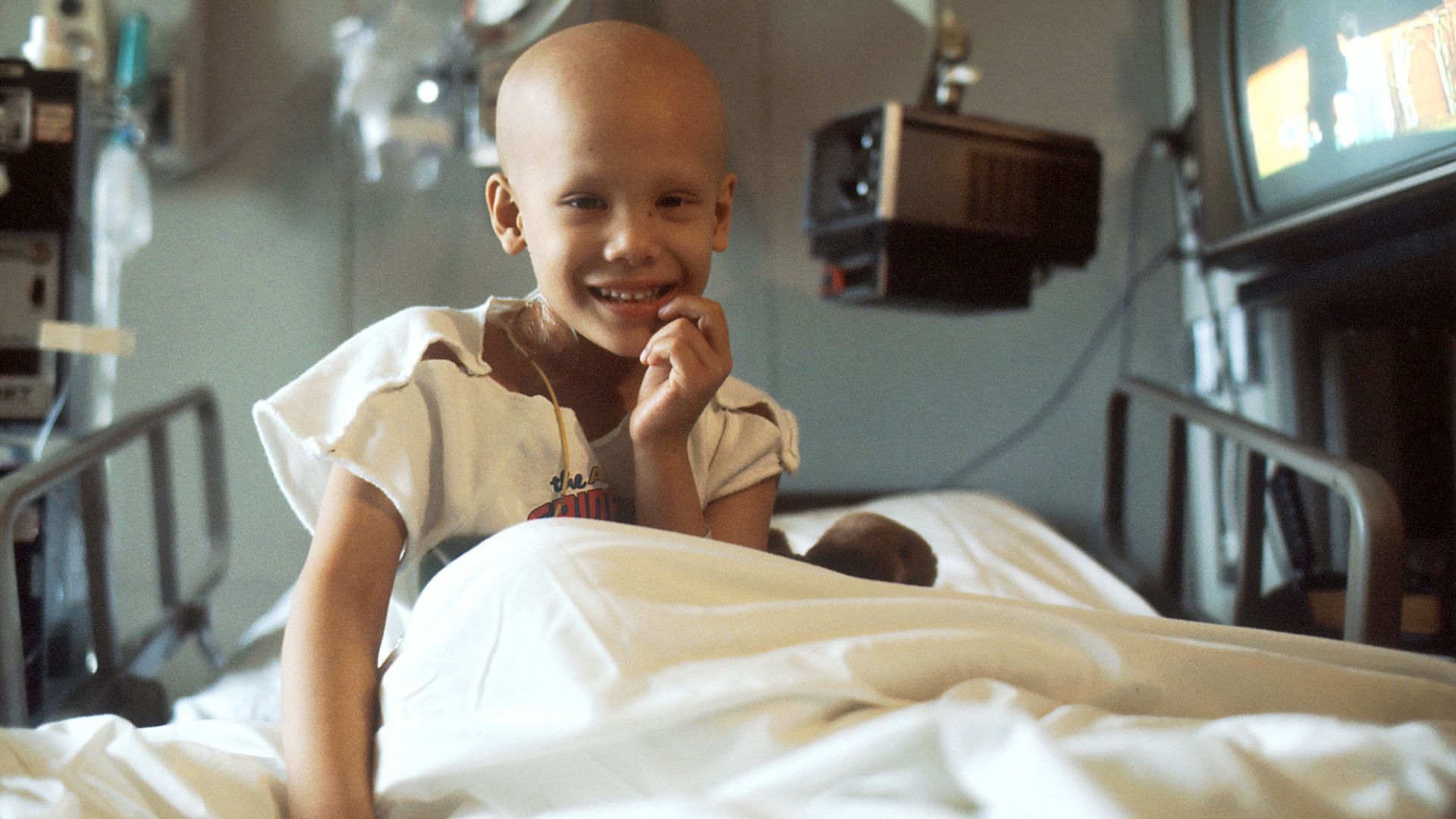 child sitting on bed