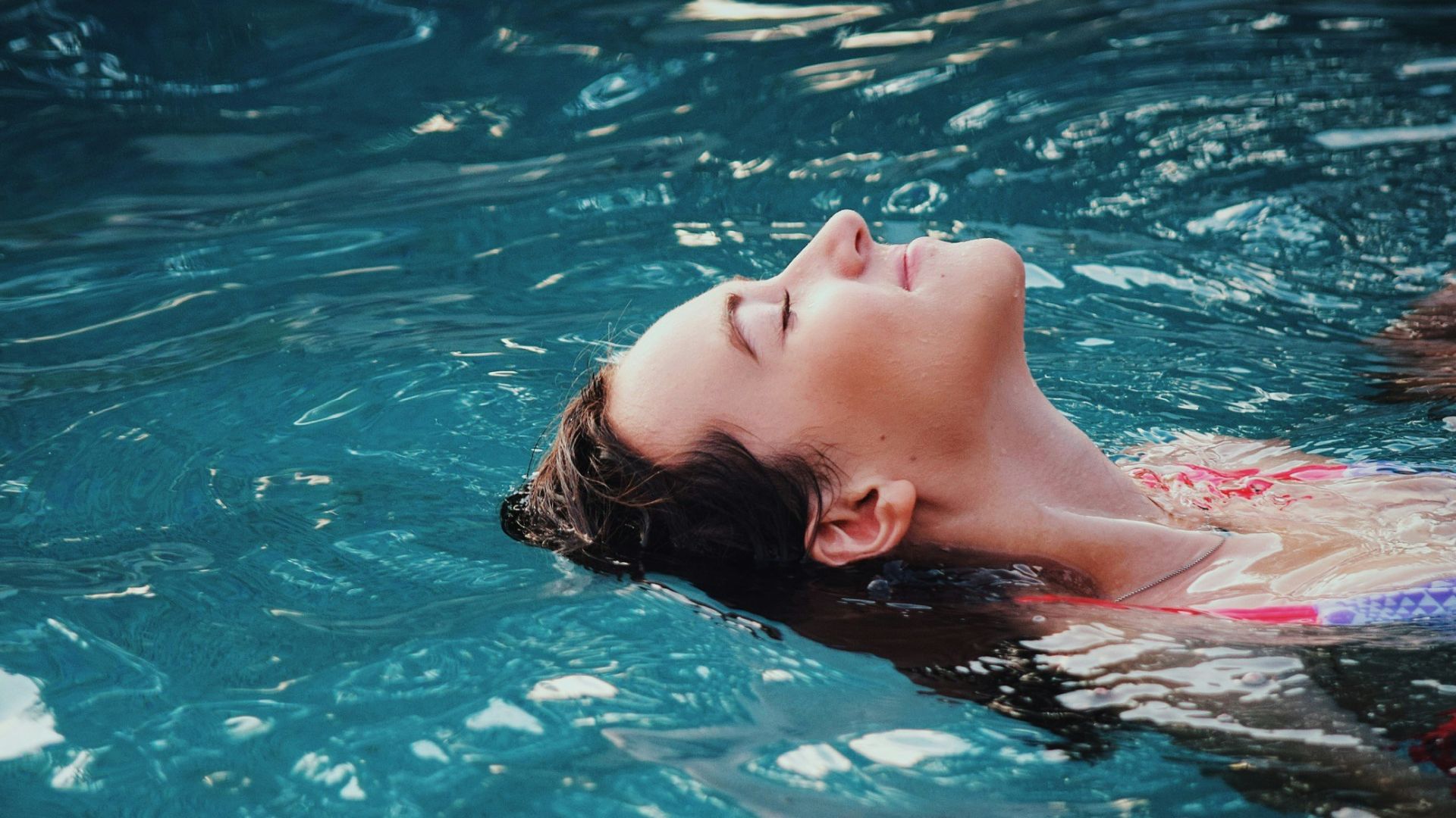woman floating on body of water
