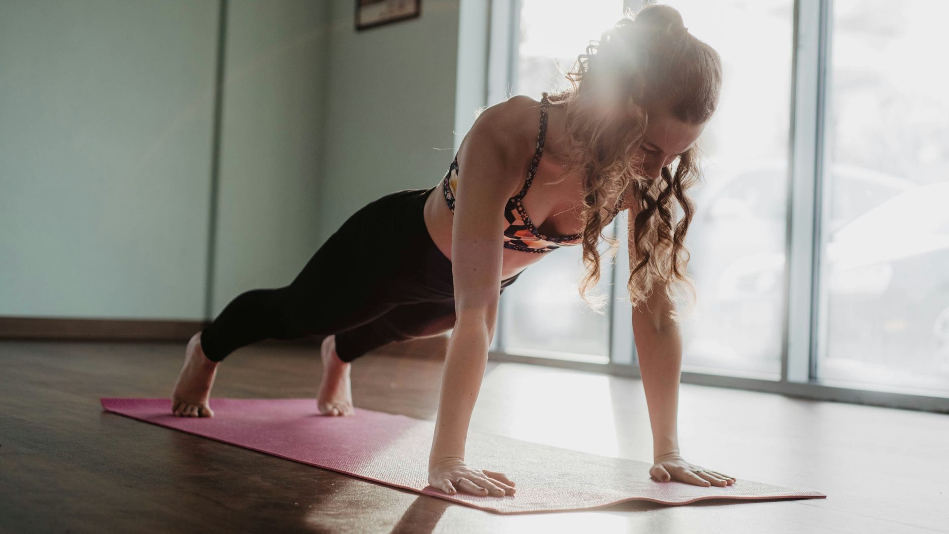 woman in black tank top and black leggings doing yoga