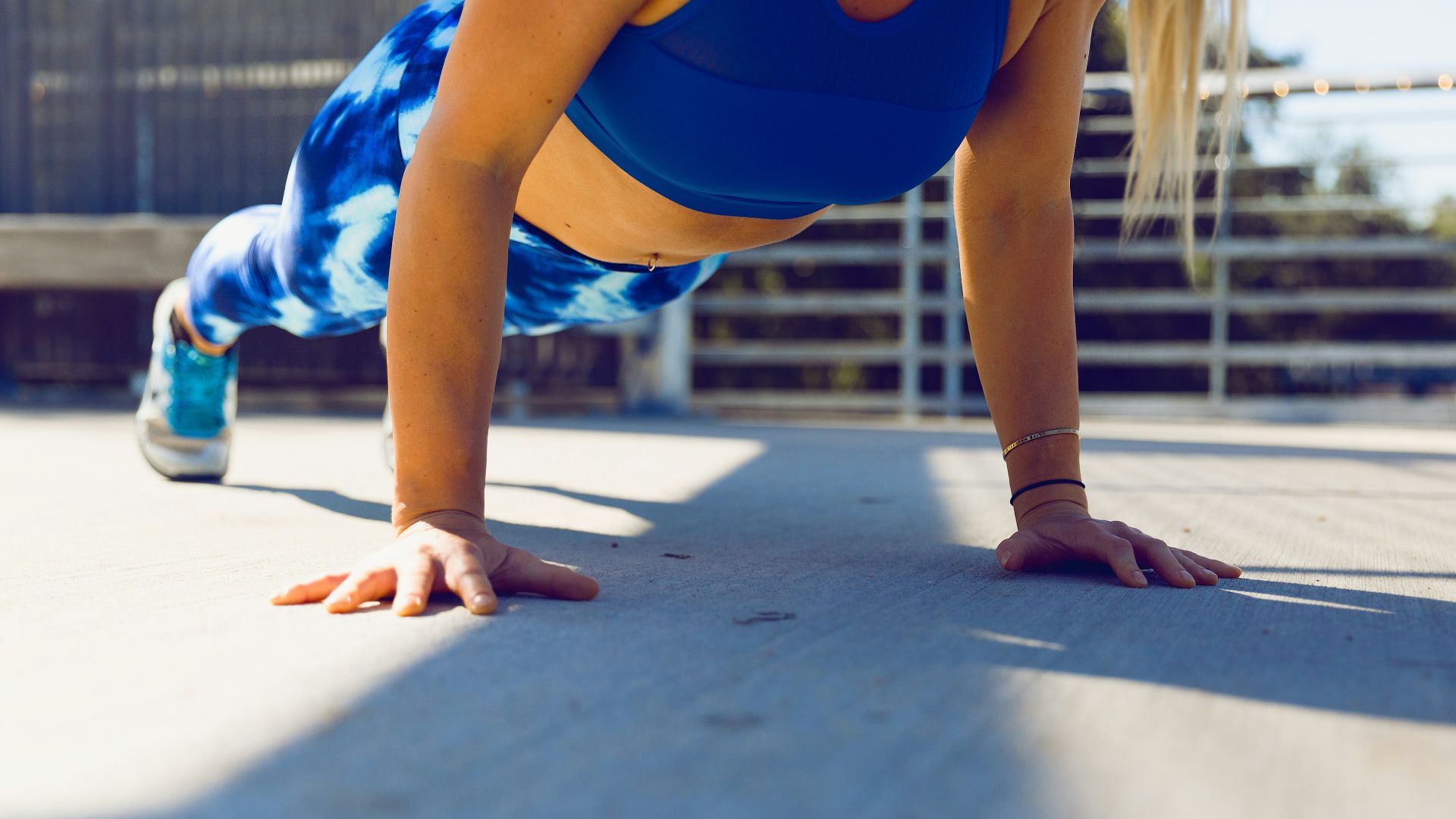 woman planking on gray asphalt road