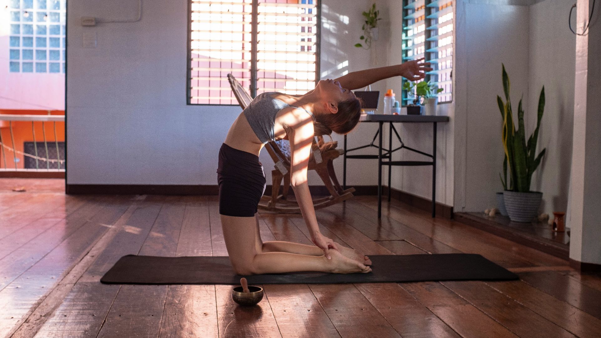 woman in black shorts and white tank top doing yoga