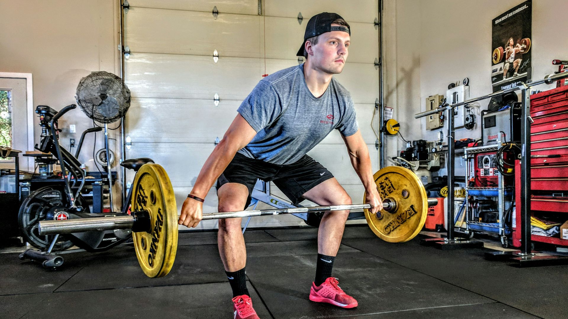 man carrying yellow barbell