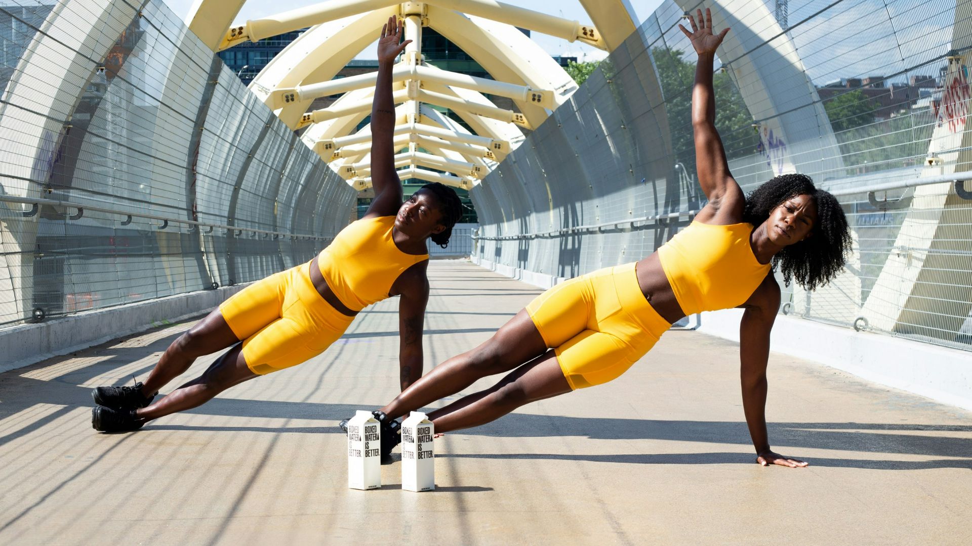woman in yellow sports bra and yellow shorts jumping on white metal frame