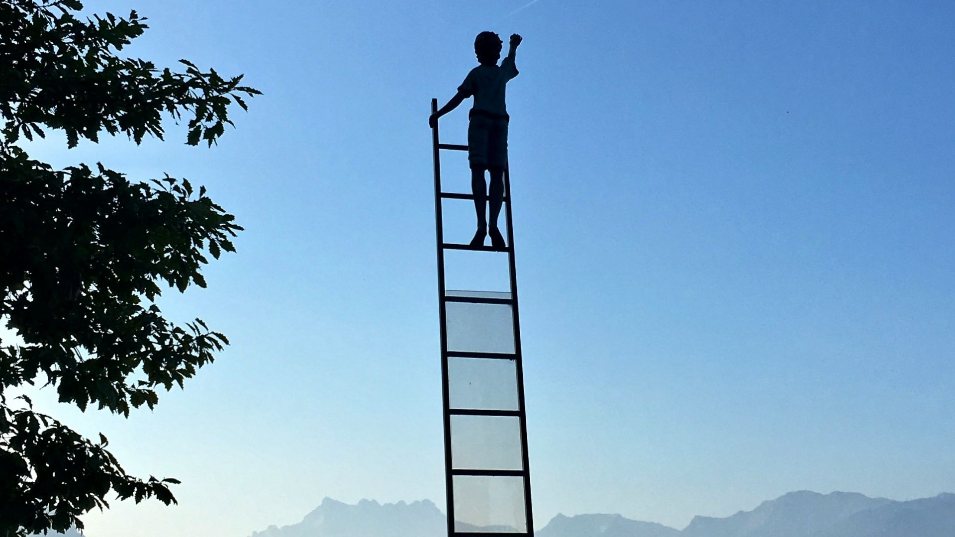 boy on ladder under blue sky