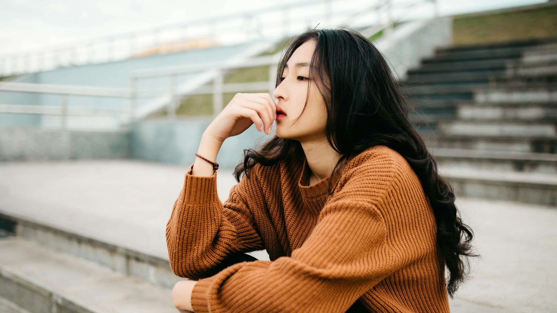 woman wearing brown sweater holding lips