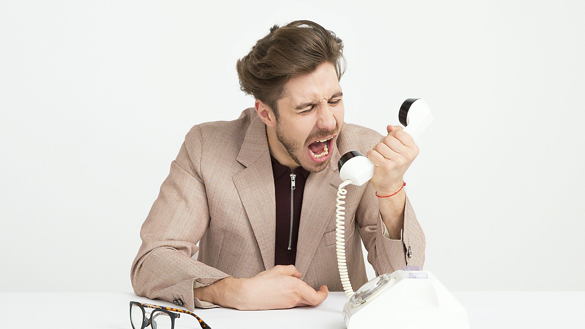 man holding telephone screaming