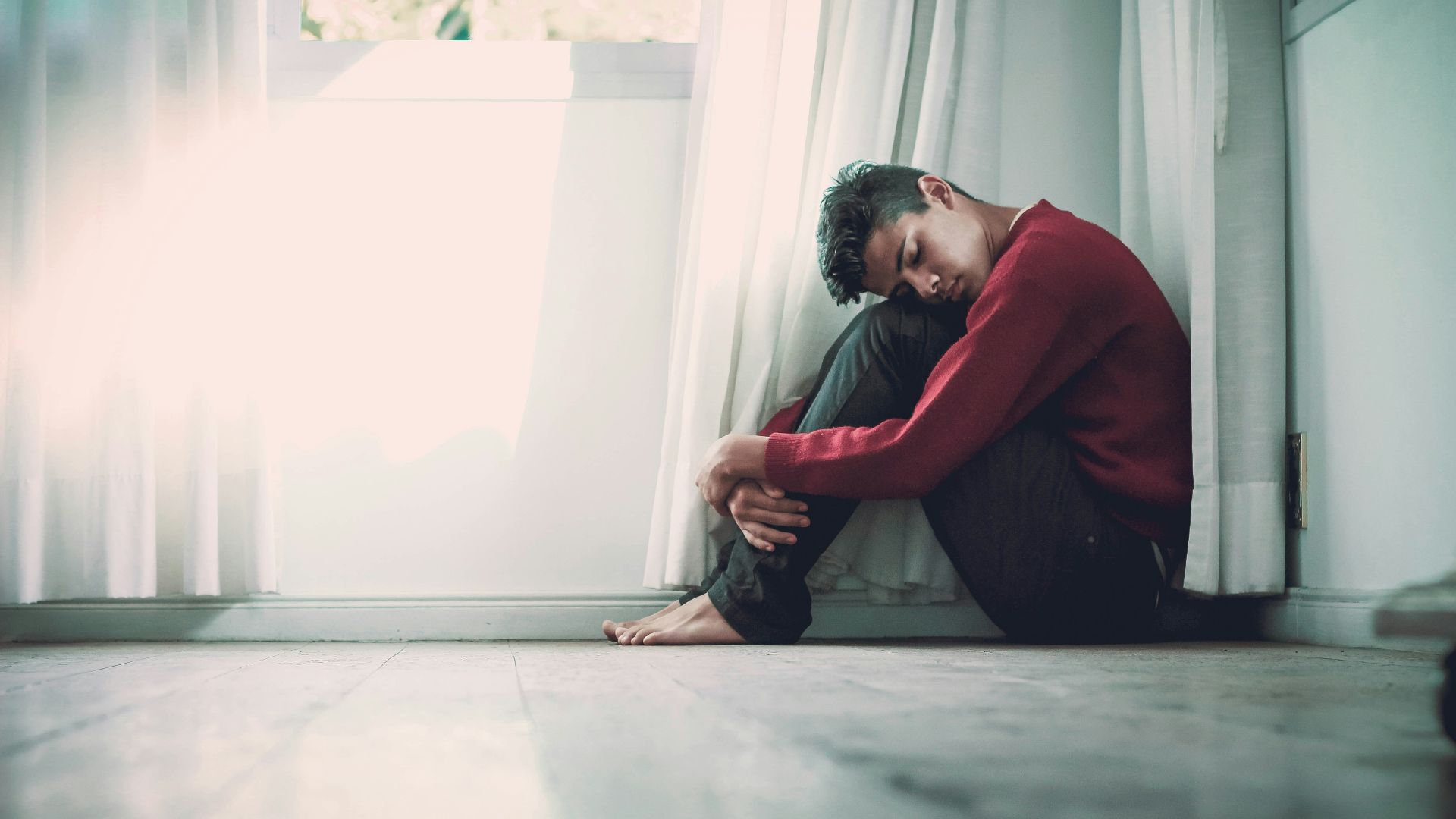 man beside white frame window